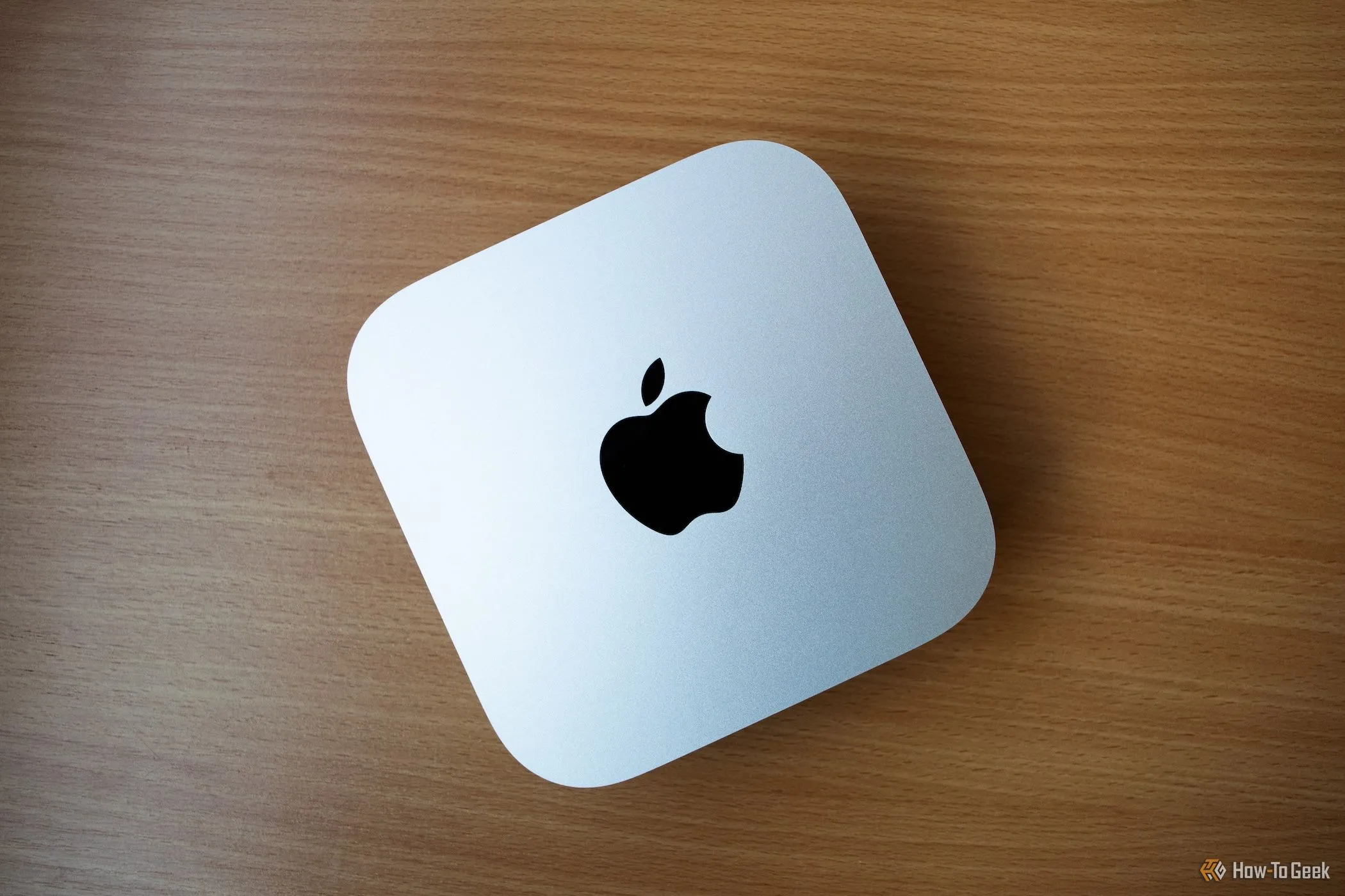 Apple Mac Mini M4 màu bạc trên bàn gỗ, thể hiện thiết kế nhỏ gọn và hiện đại
