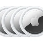 Bộ bốn thiết bị định vị Apple AirTag màu trắng, nhỏ gọn, đặt cạnh nhau trên bề mặt phản chiếu