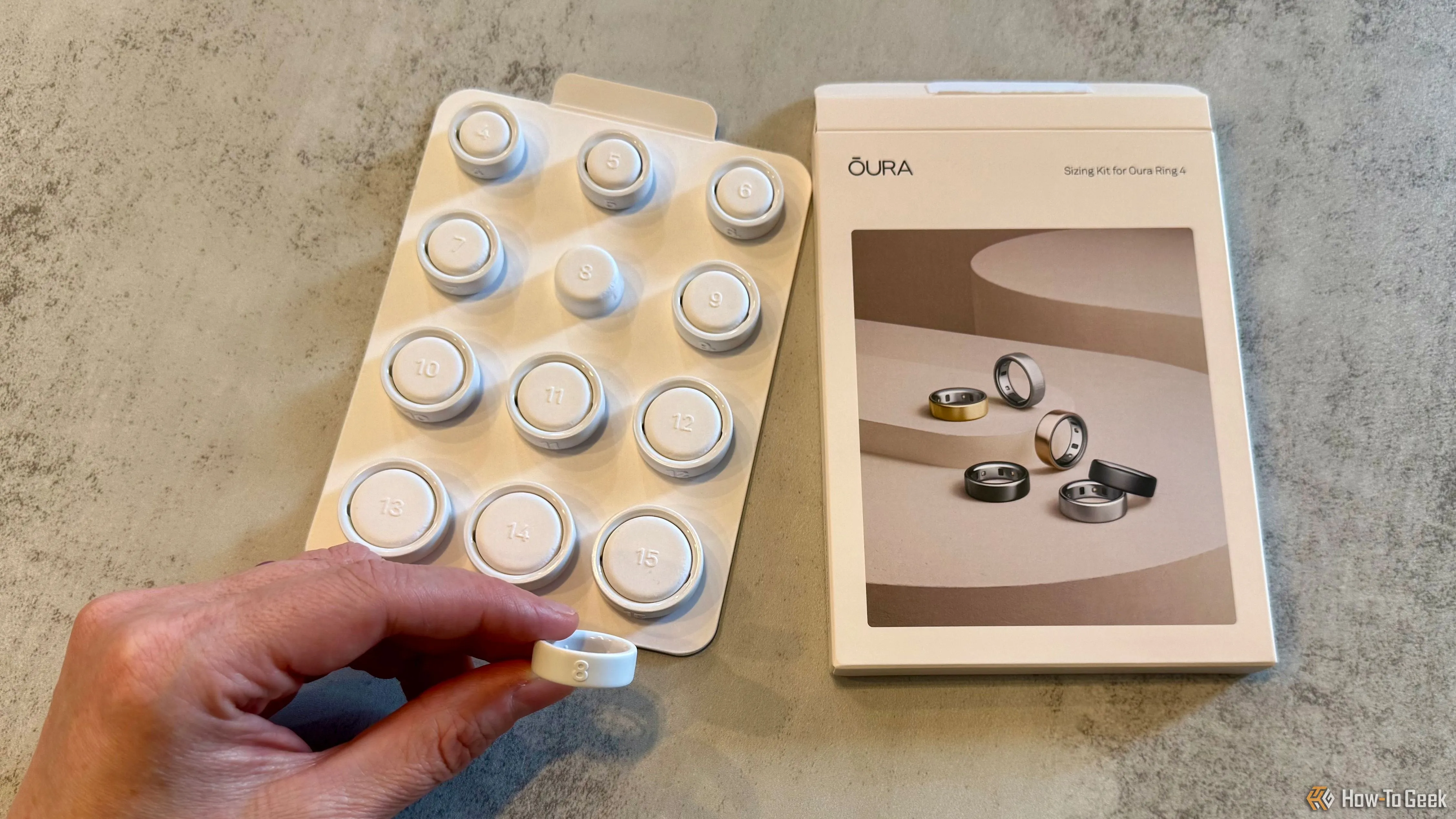 Bộ công cụ đo kích thước Oura Ring 4 với một chiếc nhẫn đo size đang được cầm