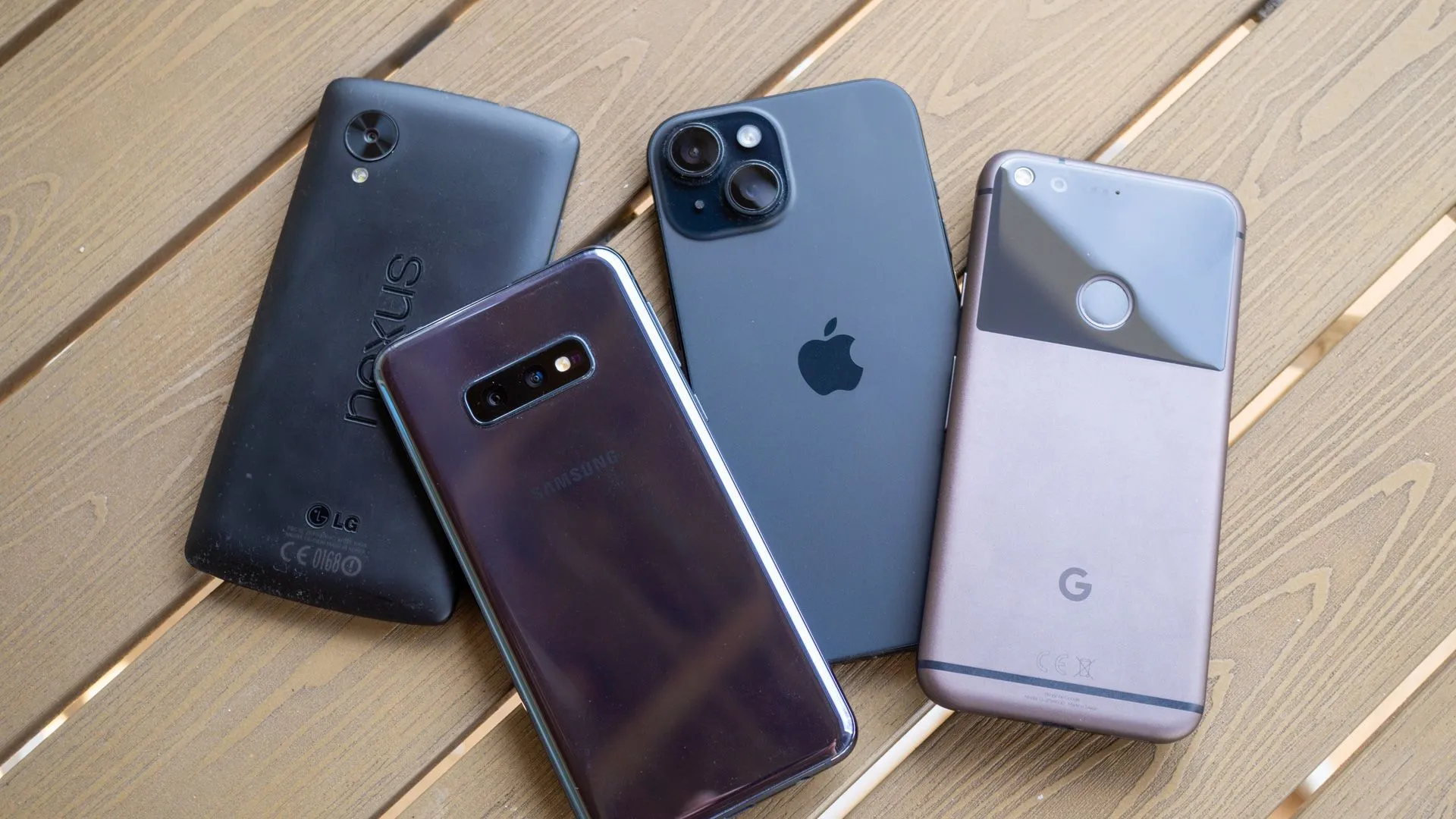 Các mẫu điện thoại Nexus 5, Galaxy S10e, iPhone 15 và Google Pixel trên mặt bàn.