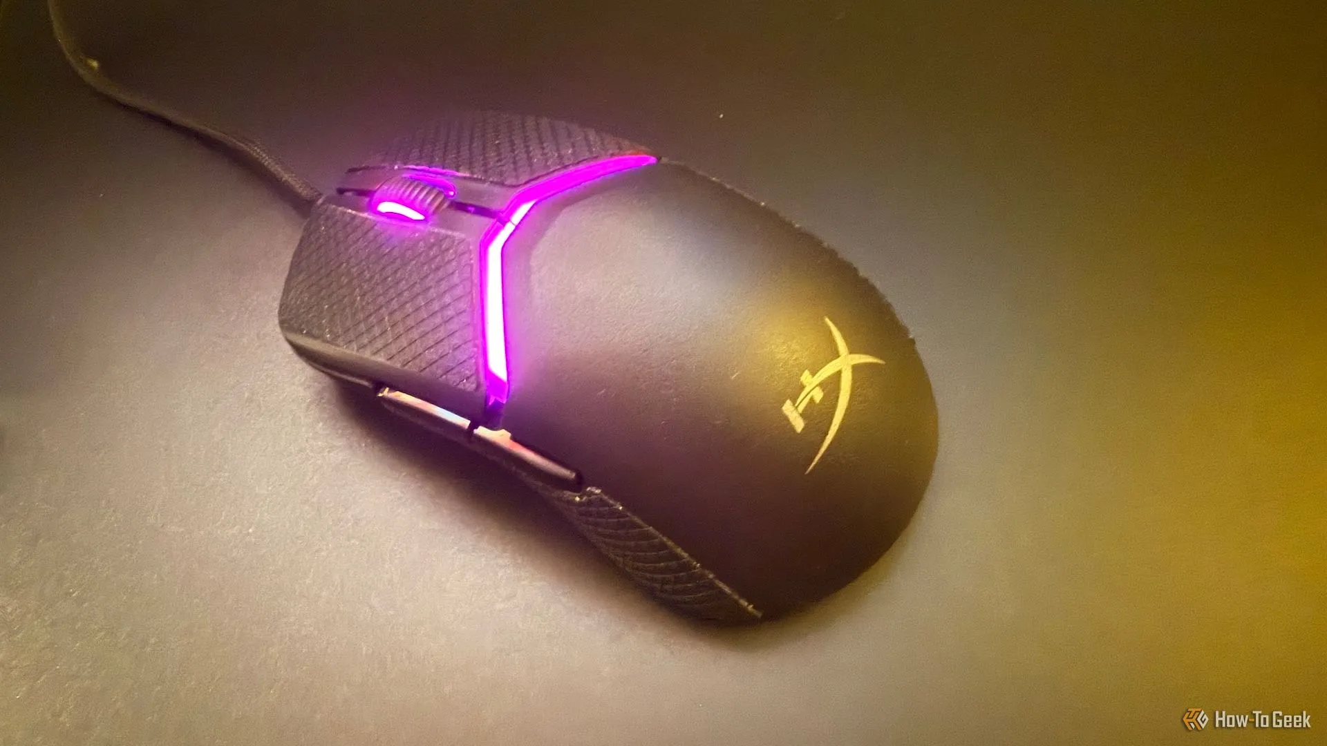 Chuột HyperX Pulsefire Saga trên bàn di chuột thủy tinh, nhìn từ góc trên xuống.