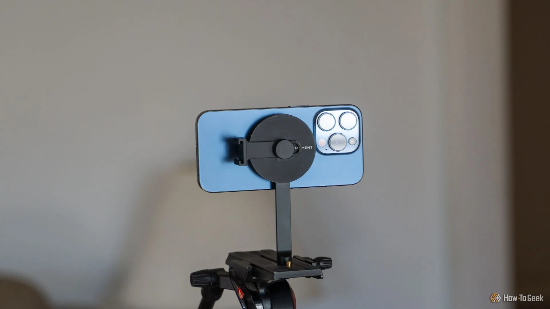 Điện thoại iPhone 15 Pro gắn ngang trên tripod MagSafe của Moment, minh họa sự tiện lợi khi chụp ảnh gia đình và du lịch.