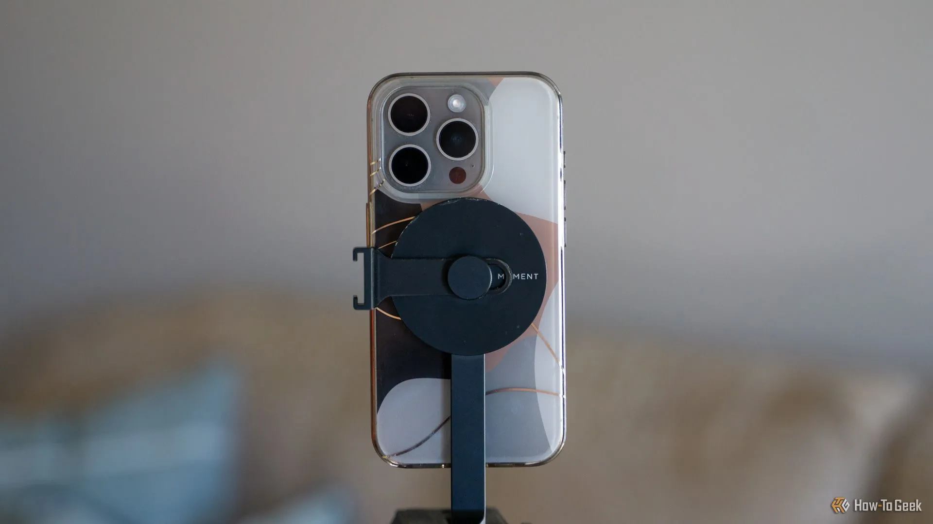 Điện thoại iPhone dùng ốp lưng MagSafe gắn vào giá đỡ tripod Moment MagSafe, minh họa khả năng tương thích rộng rãi.