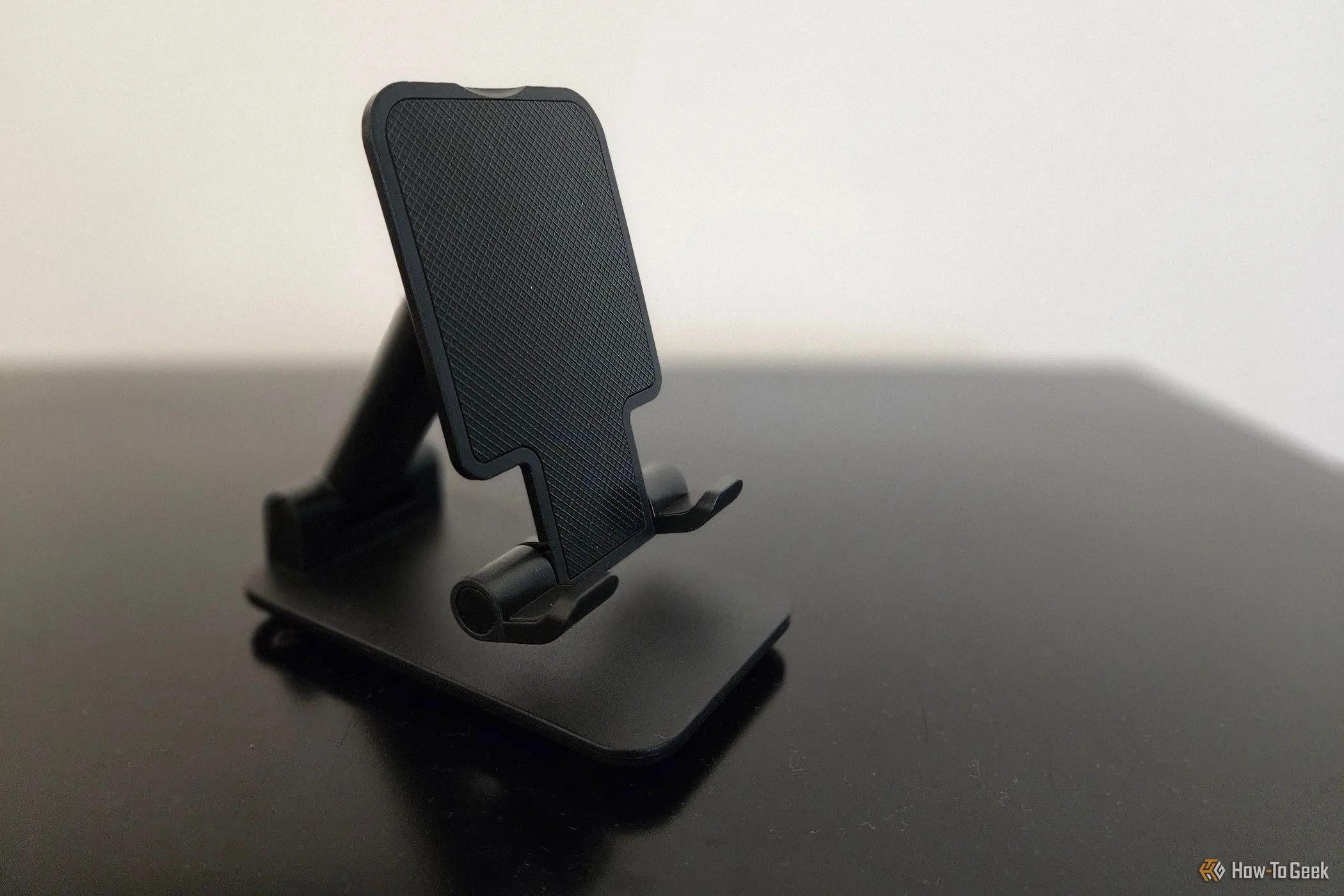 Giá đỡ điện thoại có thể gập lại màu đen, giúp cố định smartphone để xem video hoặc làm việc.