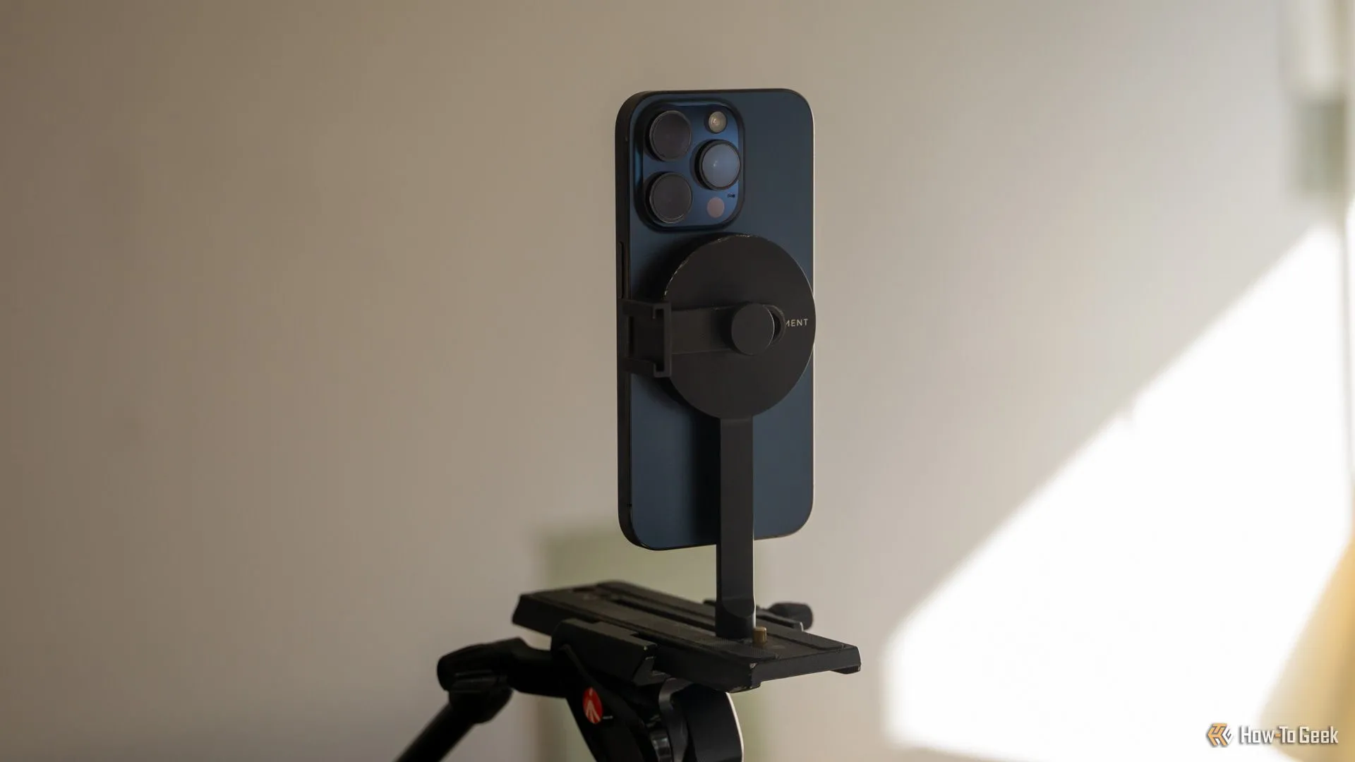 iPhone 15 Pro gắn dọc trên giá đỡ tripod Moment MagSafe, thể hiện khả năng xoay linh hoạt cho nhiếp ảnh di động.