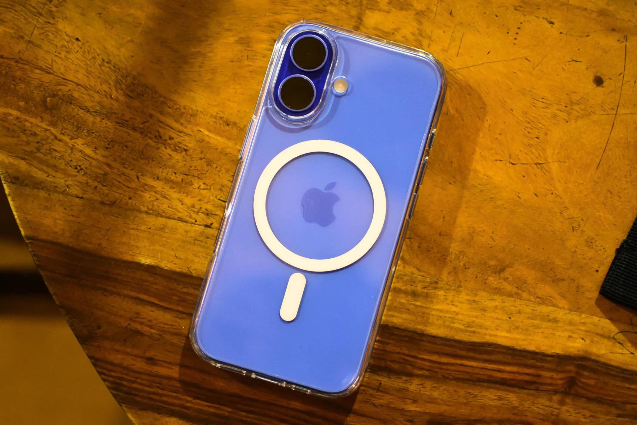 iPhone 16 màu xanh Ultramarine với ốp lưng MagSafe trong suốt, thể hiện cụm camera mới.