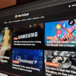 Màn hình máy tính hiển thị chế độ tối (dark mode) của một trang web công nghệ trong phòng thiếu sáng, giúp giảm mỏi mắt khi làm việc.
