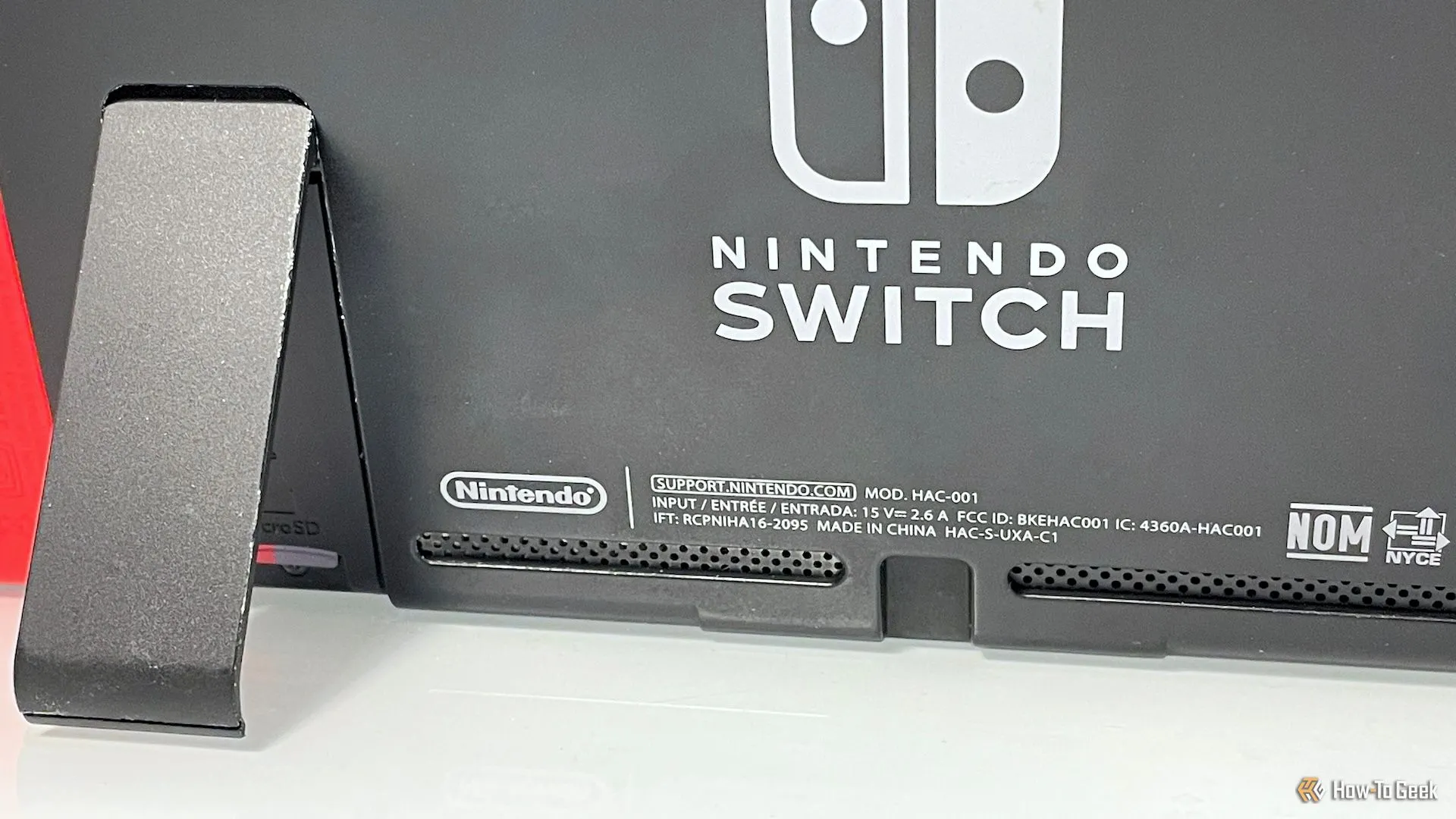 Mặt sau console Switch, được kê lên bằng chân đế để giữ các lỗ thông khí mở và hỗ trợ tản nhiệt
