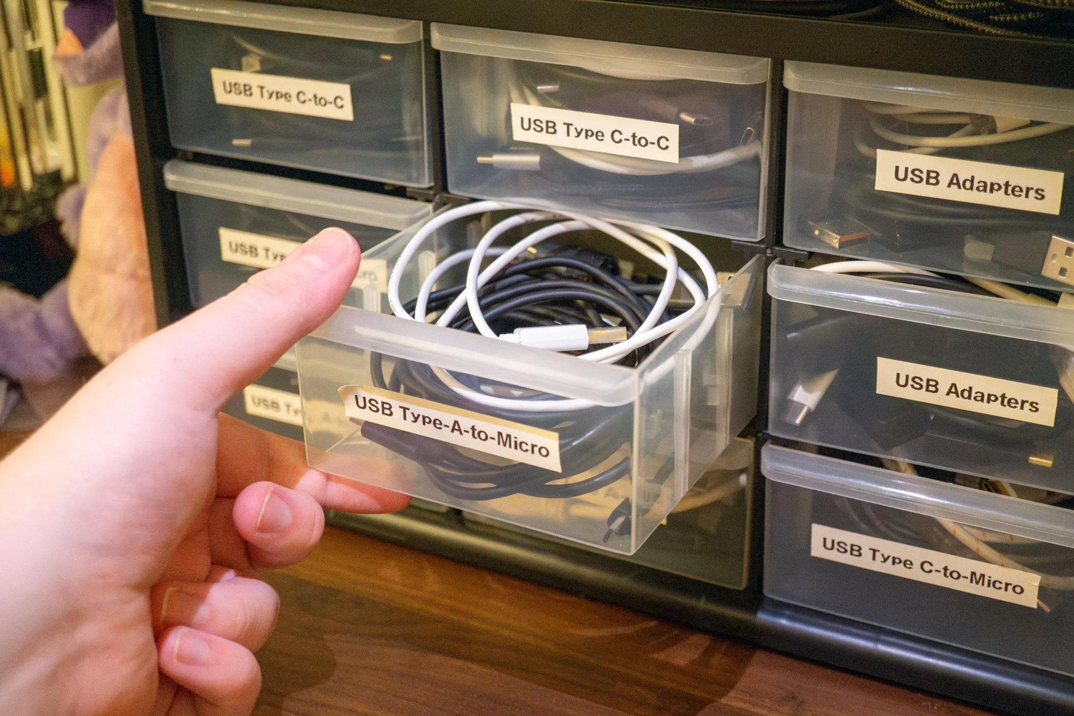 Ngăn kéo tủ đầy ắp các loại cáp USB lộn xộn, cho thấy sự cần thiết của việc tổ chức dây sạc