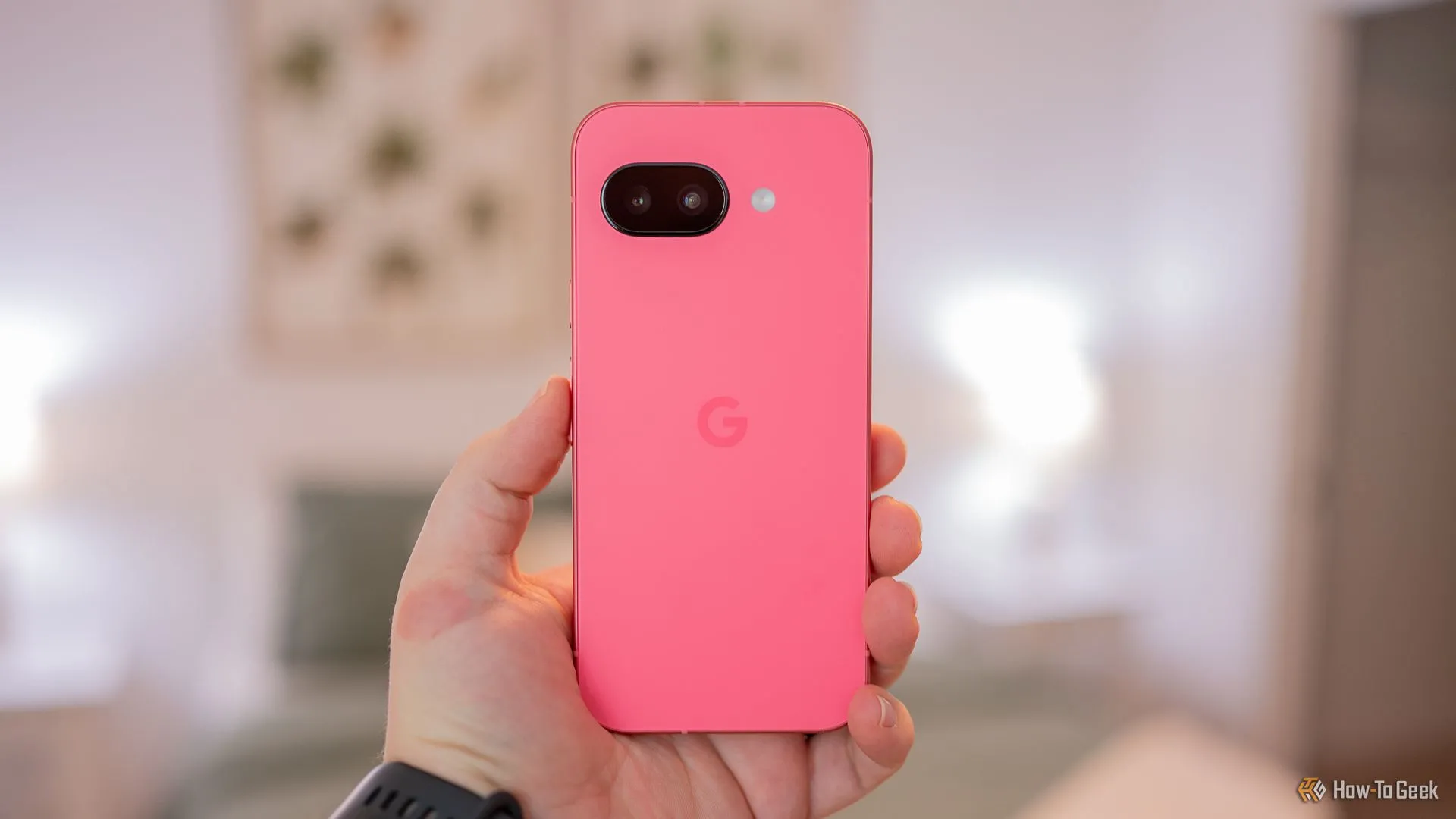 Người dùng cầm điện thoại Google Pixel 9a màu đen, thể hiện mặt lưng và cụm camera đặc trưng