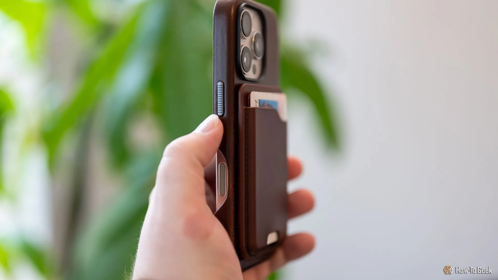 Người dùng cầm Ví da Nomad Mag gắn vào iPhone