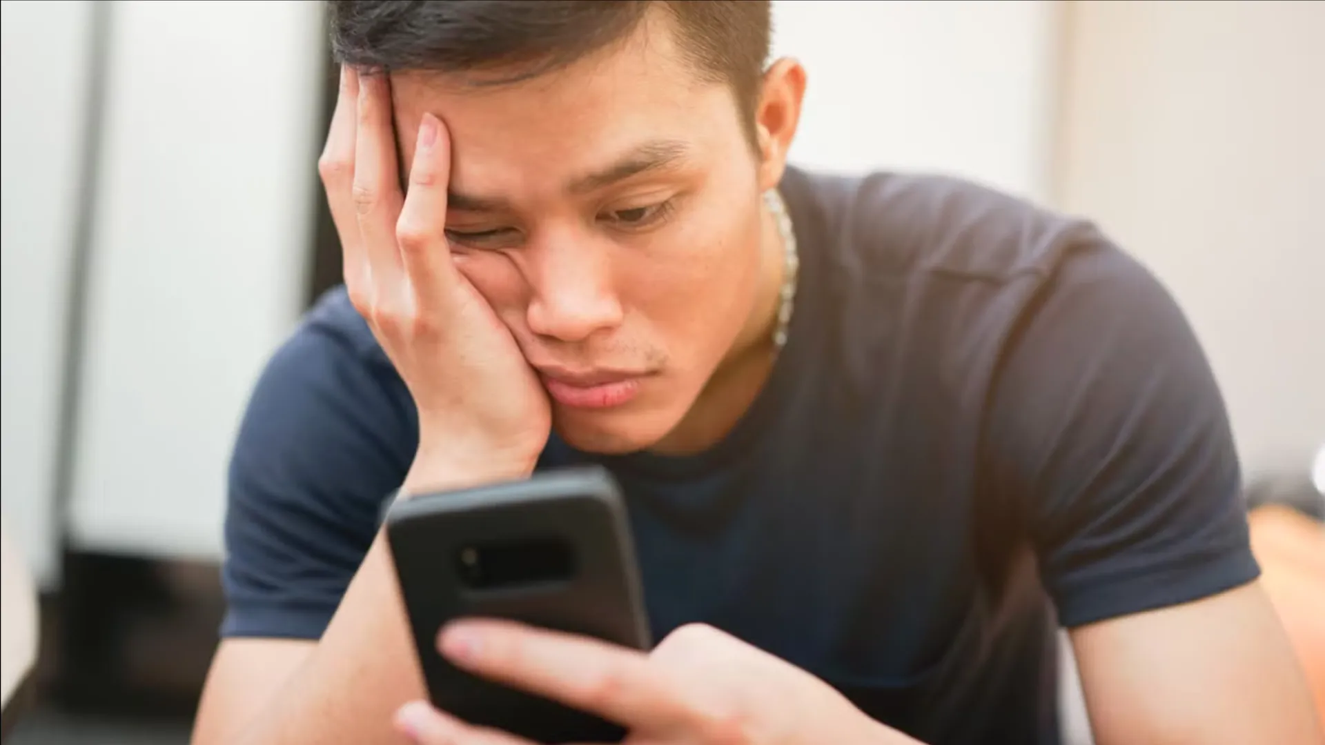 Người dùng đang lướt điện thoại với biểu cảm chán nản, thể hiện sự lãng phí thời gian vào các nội dung vô bổ (doomscrolling)