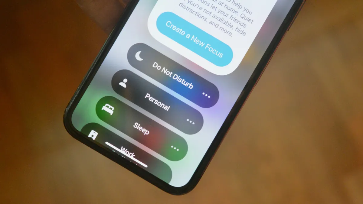 Người dùng iPhone đang cài đặt Chế độ Tập trung để tăng năng suất làm việc và học tập hiệu quả