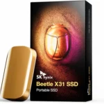 Ổ cứng SSD di động SK hynix Beetle X31 1TB màu vàng champagne đặt cạnh hộp đựng trên nền trắng, nổi bật thiết kế nhỏ gọn và cao cấp.