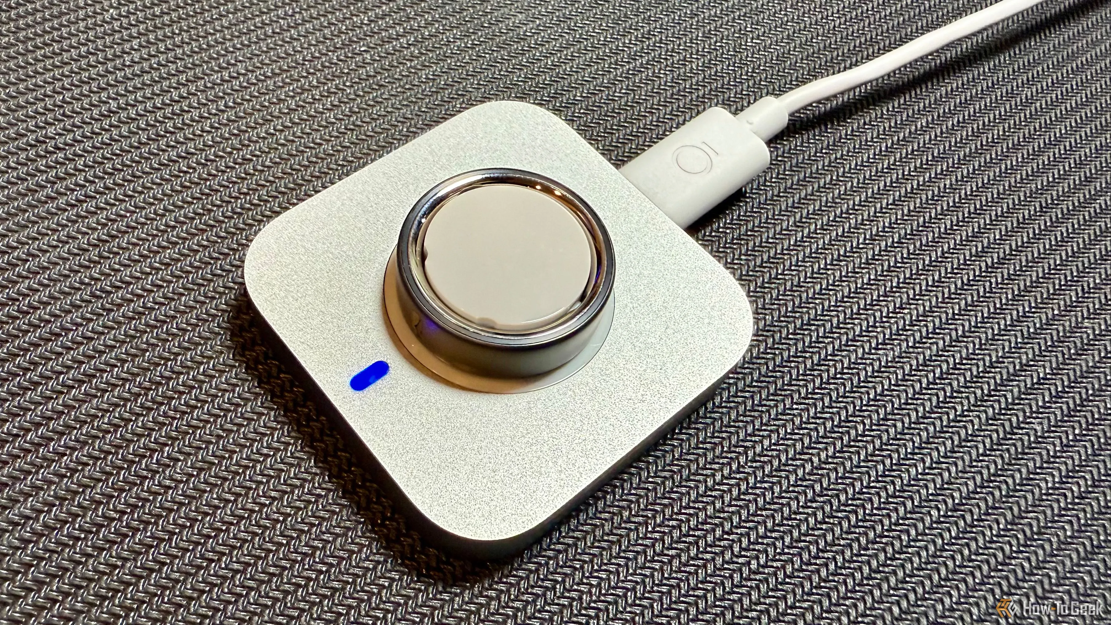 Oura Ring 4 đang được sạc trên đế