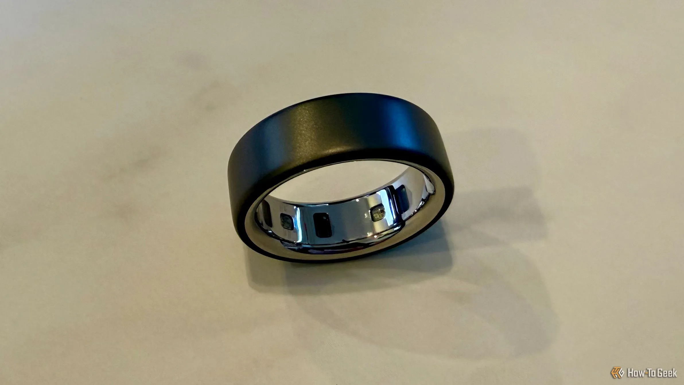 Oura Ring 4 đặt trên mặt bàn, hiển thị các cảm biến bên trong