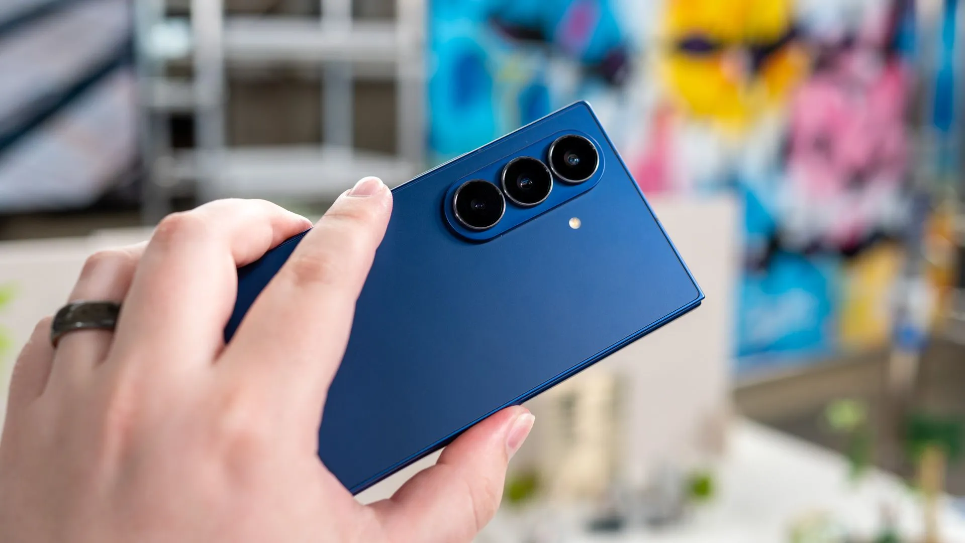 person holding the samsung galaxy z fold 7 unfolded showing the back of the phone and cameras