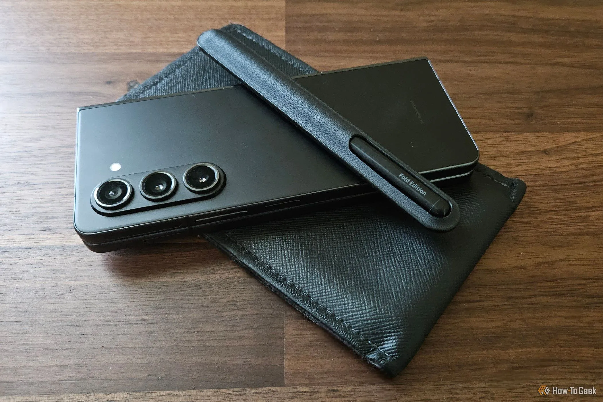 Samsung Galaxy Z Fold 5 đặt cạnh bao đựng chuyên dụng có khe cắm bút S Pen lớn, tiện lợi khi di chuyển