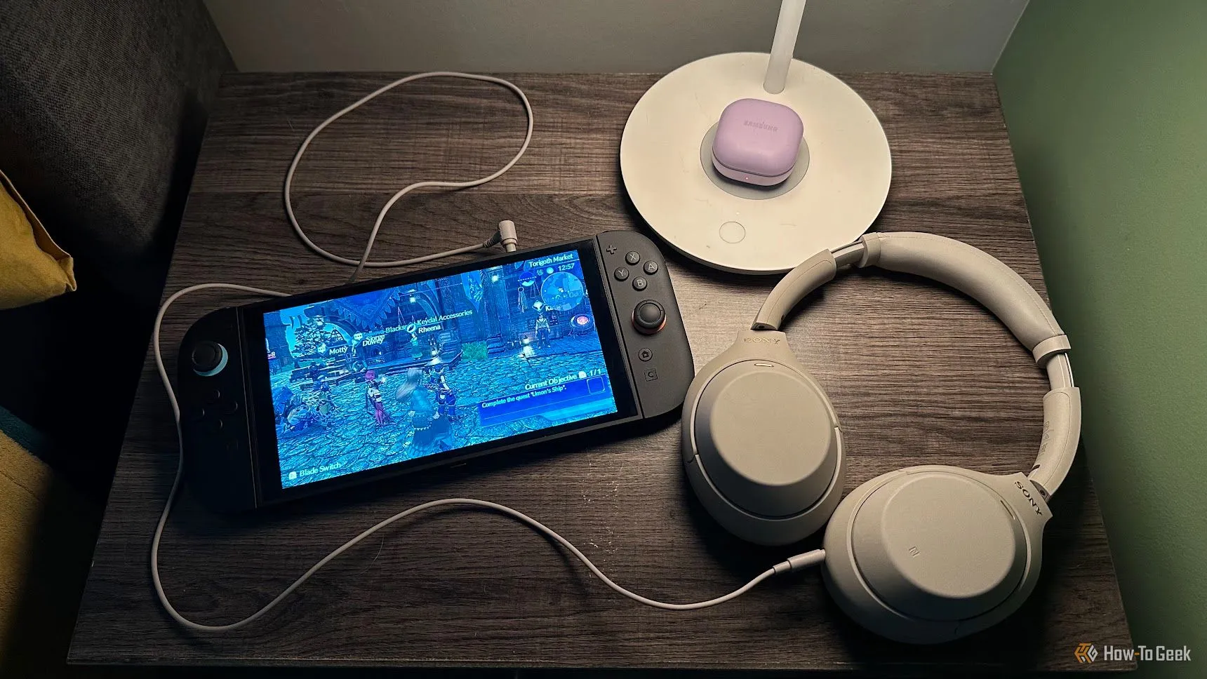 Bàn đầu giường với máy chơi game Nintendo Switch 2 và tai nghe Sony WH-1000XM4