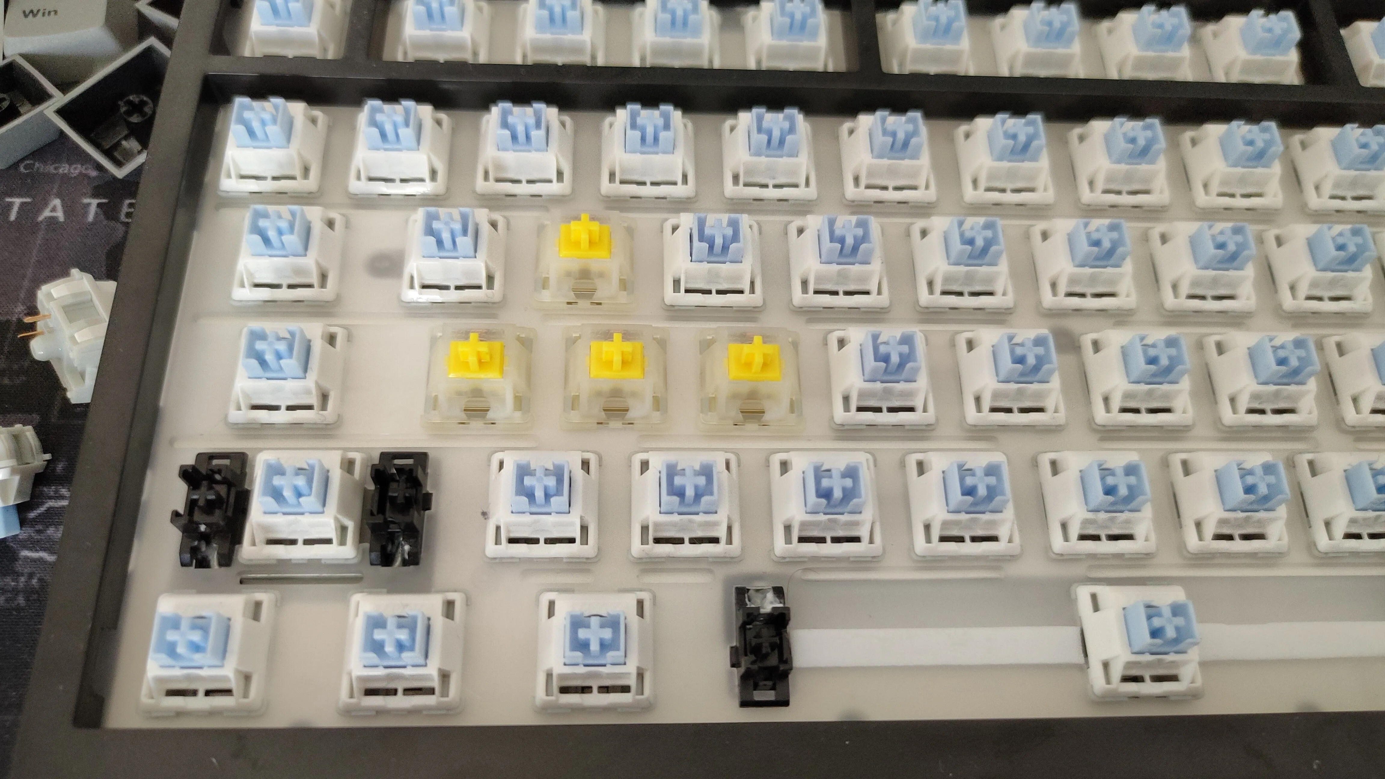 Bàn phím cơ với các keycap đã tháo, lộ ra một số switch Gateron Yellow được lắp ở vị trí WASD