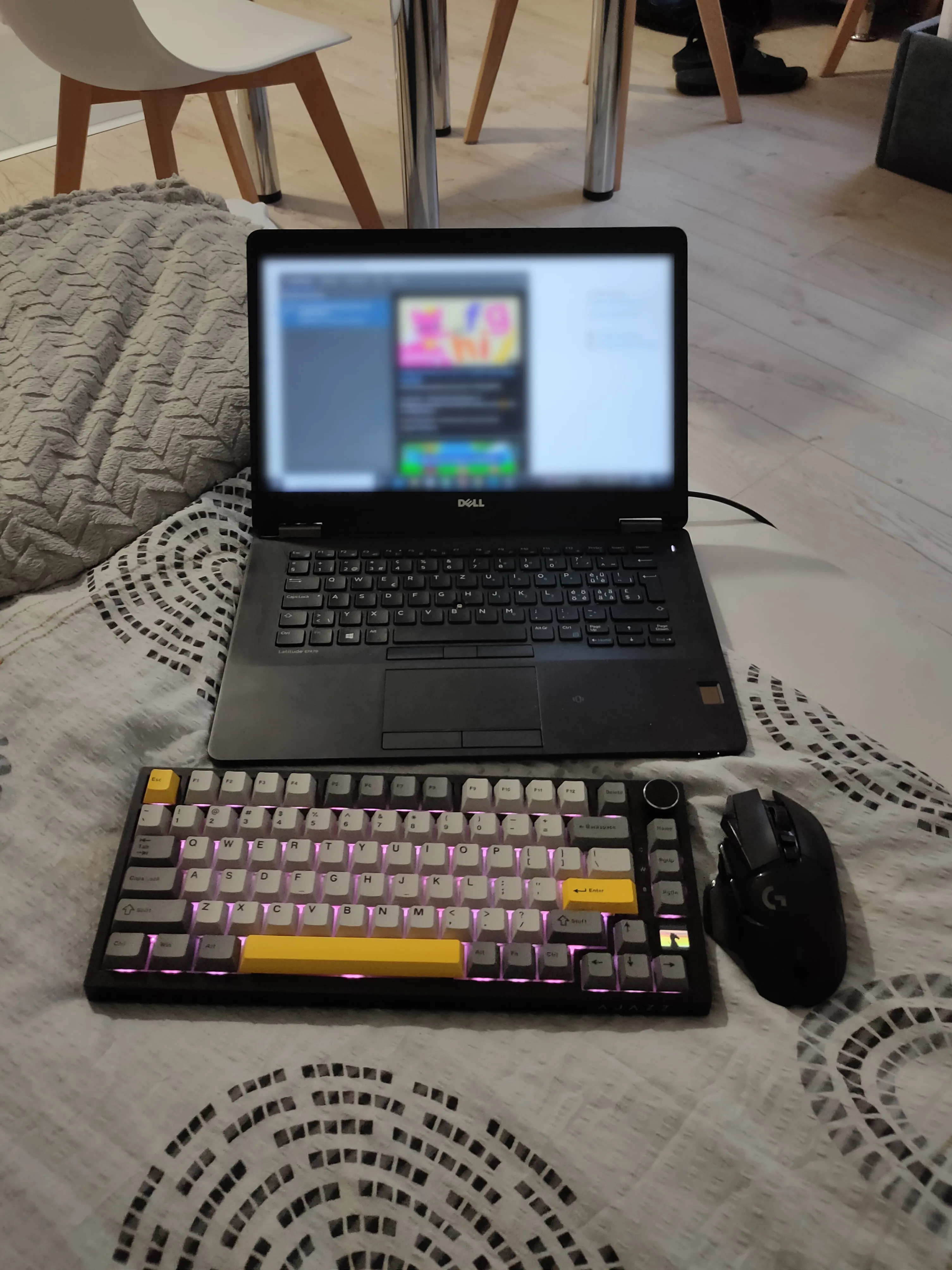 Bàn phím và chuột không dây đặt cạnh laptop, giúp tối ưu không gian và tư thế chơi game thoải mái.