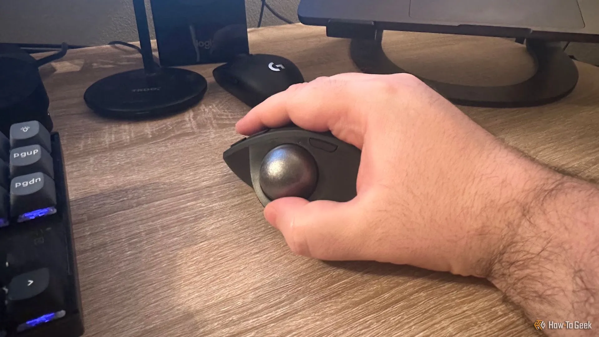 Bàn tay người dùng đang cầm chuột Logitech MX Ergo S, minh họa thiết kế công thái học
