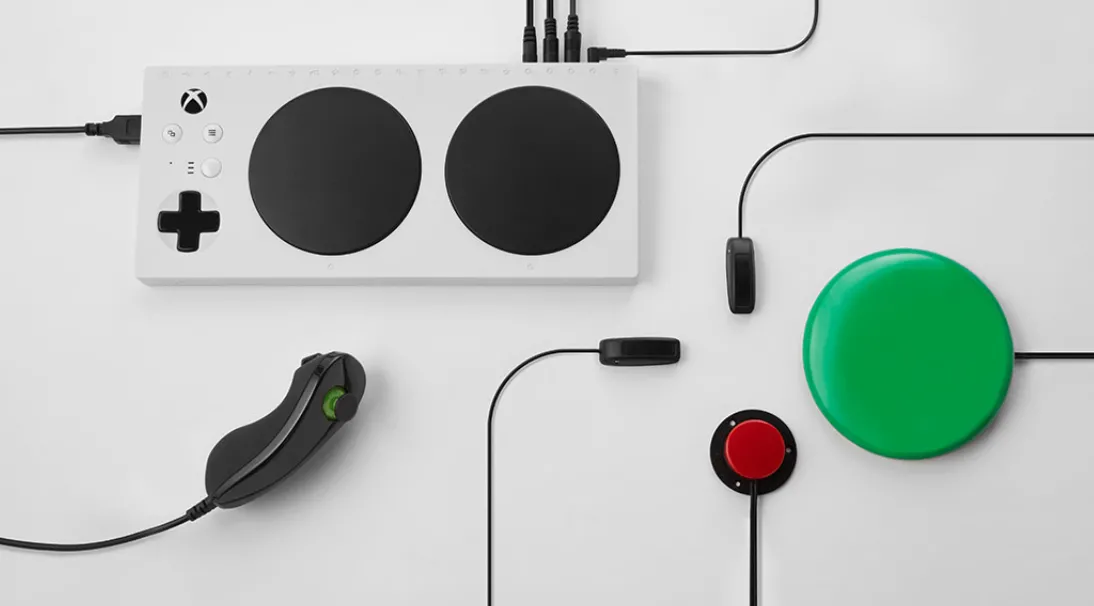 Bộ điều khiển Xbox Adaptive Controller kết nối với joystick, nút bấm đỏ và xanh lá qua cổng 3.5mm, minh họa khả năng mở rộng