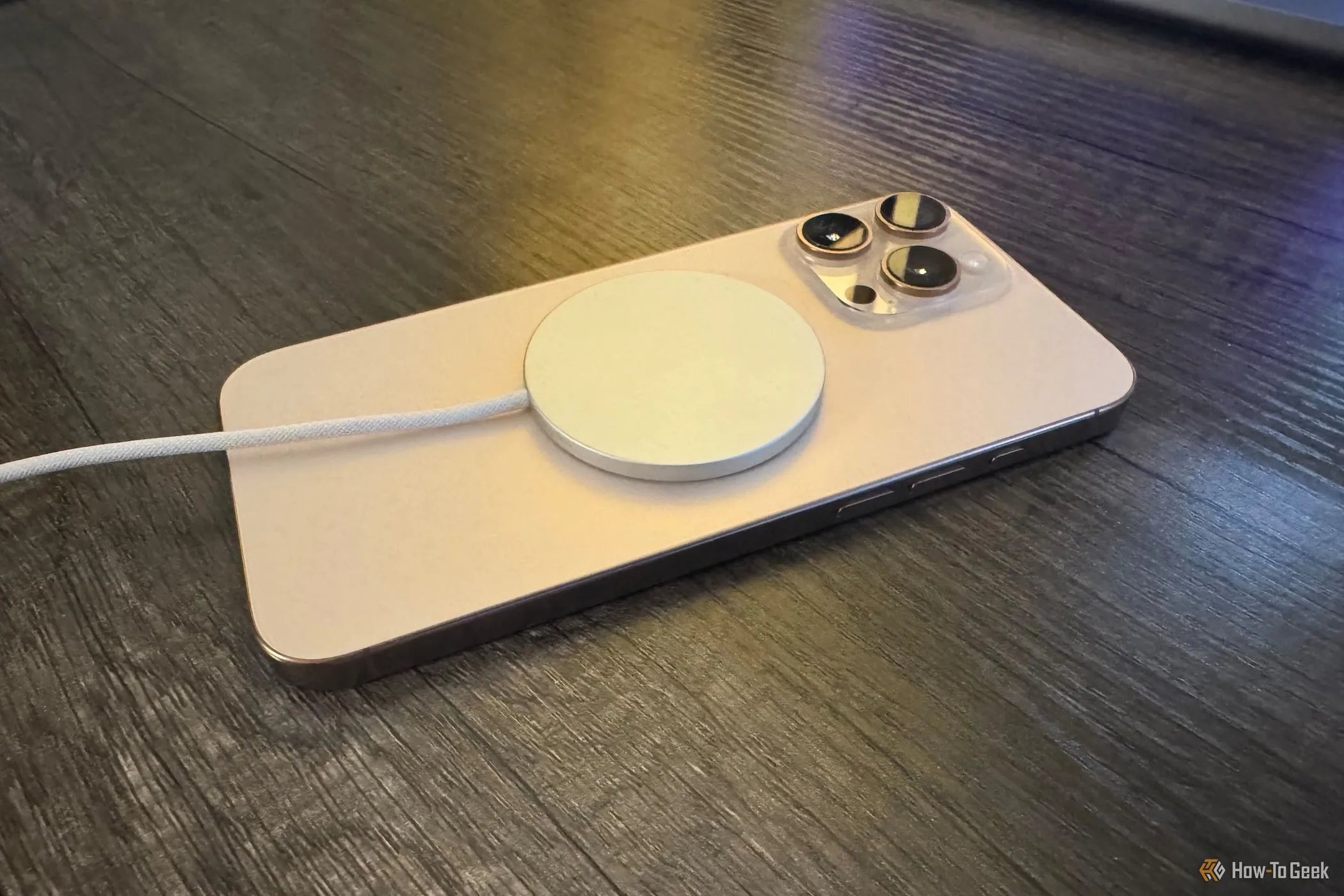 Bộ sạc Apple MagSafe gắn vào iPhone 16 Pro Max từ một góc
