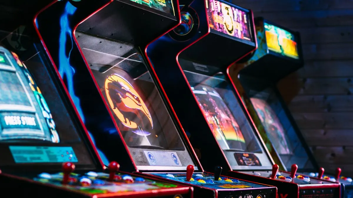 Bộ sưu tập các máy game arcade cổ điển với đèn neon sáng trong một căn phòng tối