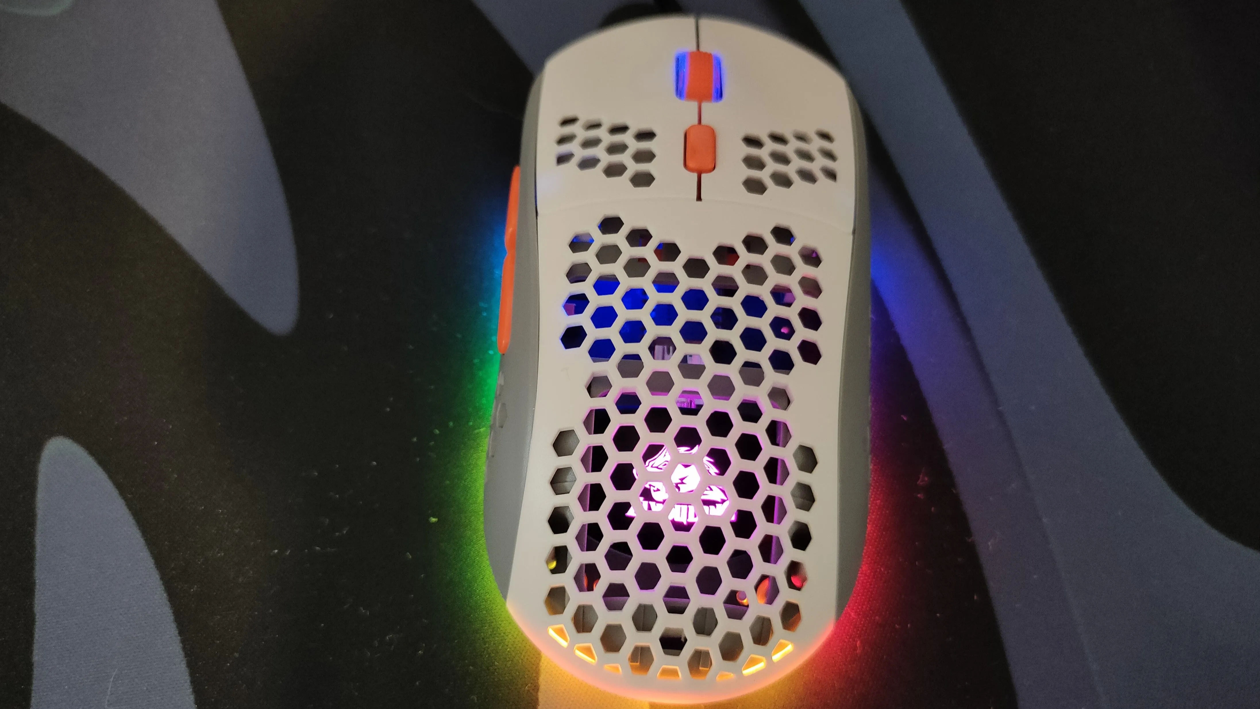 Chuột gaming trắng có lỗ và đèn RGB đang hoạt động