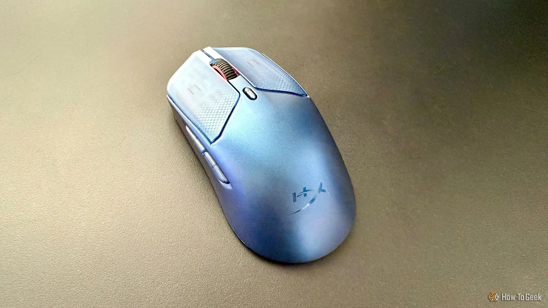 Chuột HyperX Pulsefire Haste 2 S đặt trên bàn làm việc hoặc gaming, với ánh sáng RGB nổi bật