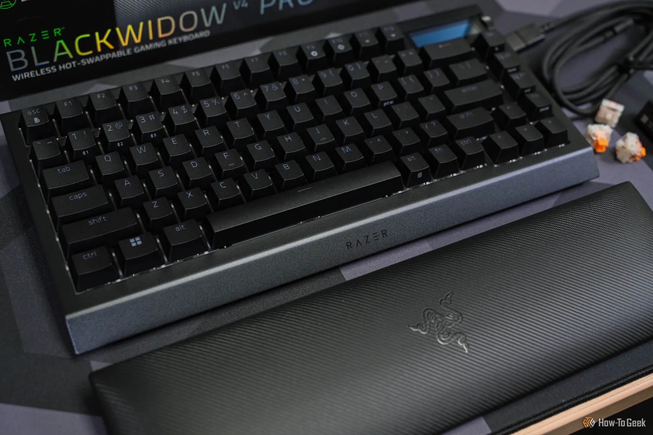 Đệm kê cổ tay màu đen đặt dưới bàn phím cơ Razer BlackWidow V4 Pro 75%, minh họa giải pháp cho sự khó chịu khi sử dụng lót chuột kính.