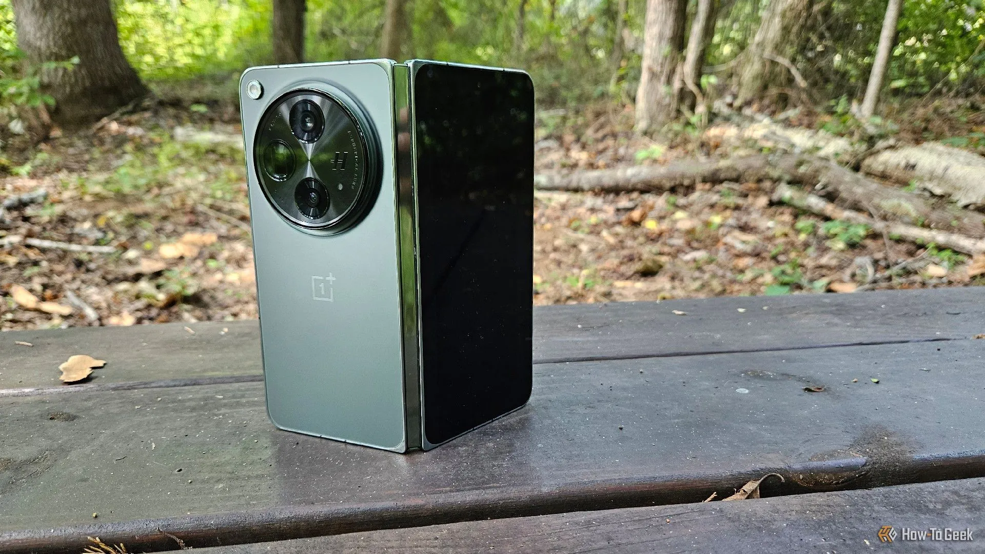Điện thoại gập OnePlus Open được đặt thẳng đứng trên ghế đá, thể hiện thiết kế sang trọng và khả năng sử dụng linh hoạt.