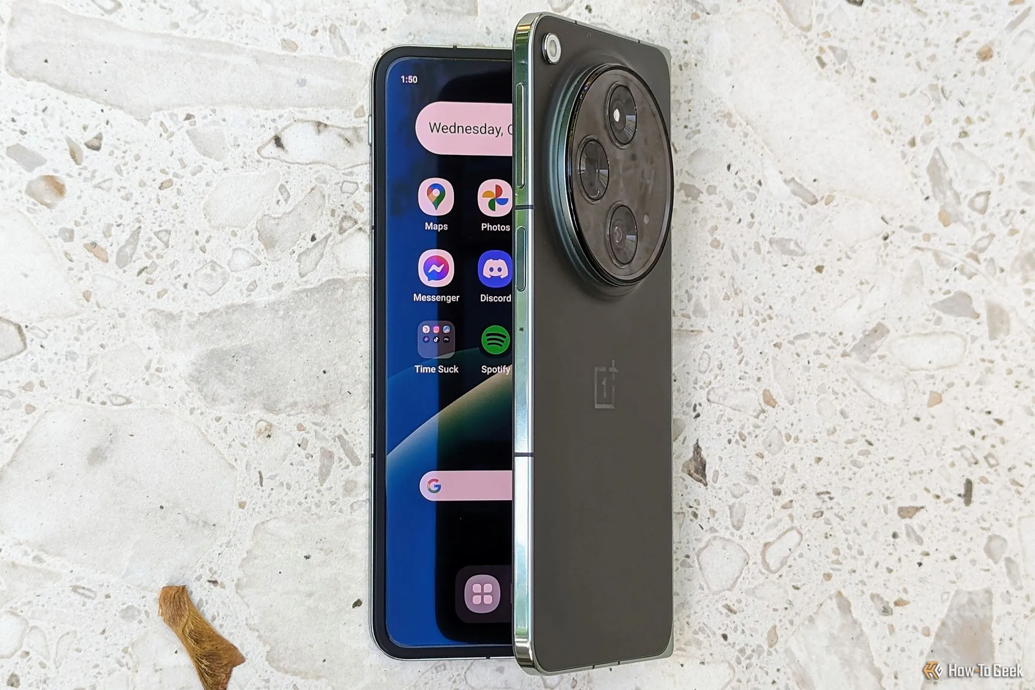 Điện thoại OnePlus Open đang mở hé trên mặt bàn, phô diễn thiết kế gập