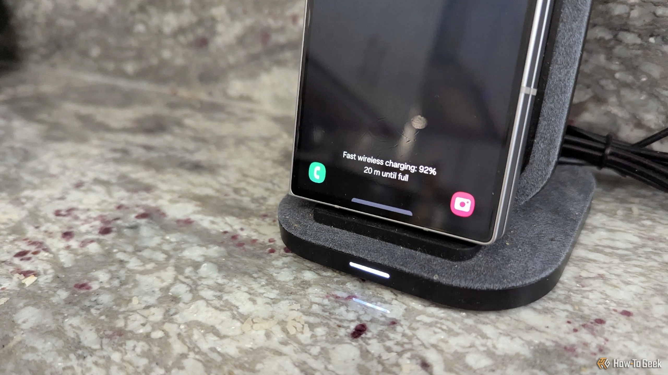Điện thoại Samsung Galaxy Z Fold 6 đang sạc trên đế sạc không dây đứng, minh họa nhược điểm tốc độ sạc chậm và hạn chế di chuyển