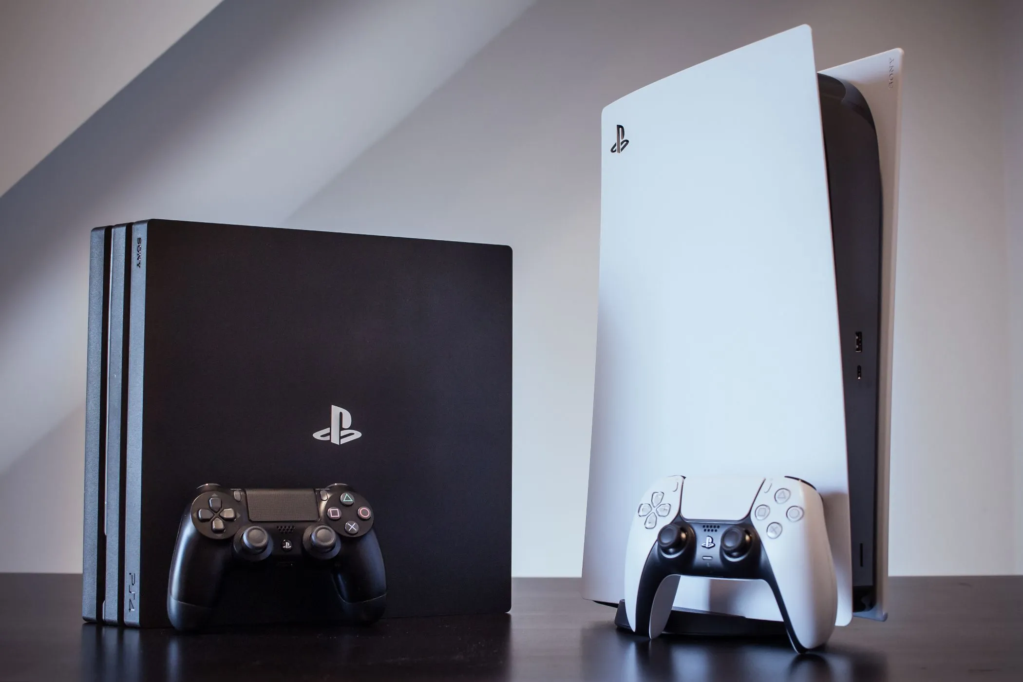 Hai hệ máy console PS4 Pro và PS5 đặt cạnh nhau, minh họa sự khác biệt về đồ họa và hiệu năng giữa các thế hệ gần đây.