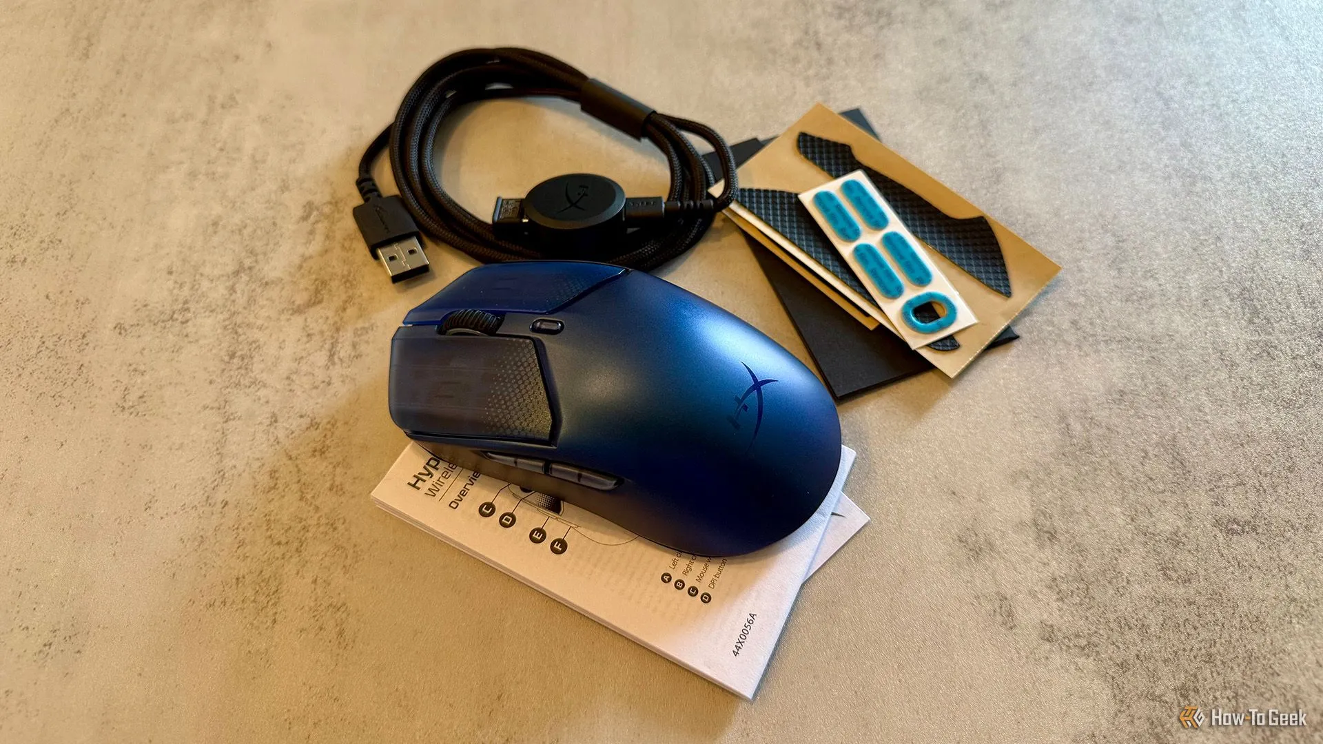 Hình ảnh các phụ kiện đi kèm chuột HyperX Pulsefire Haste 2 S, bao gồm cáp sạc, dongle, grip tape và feet dự phòng