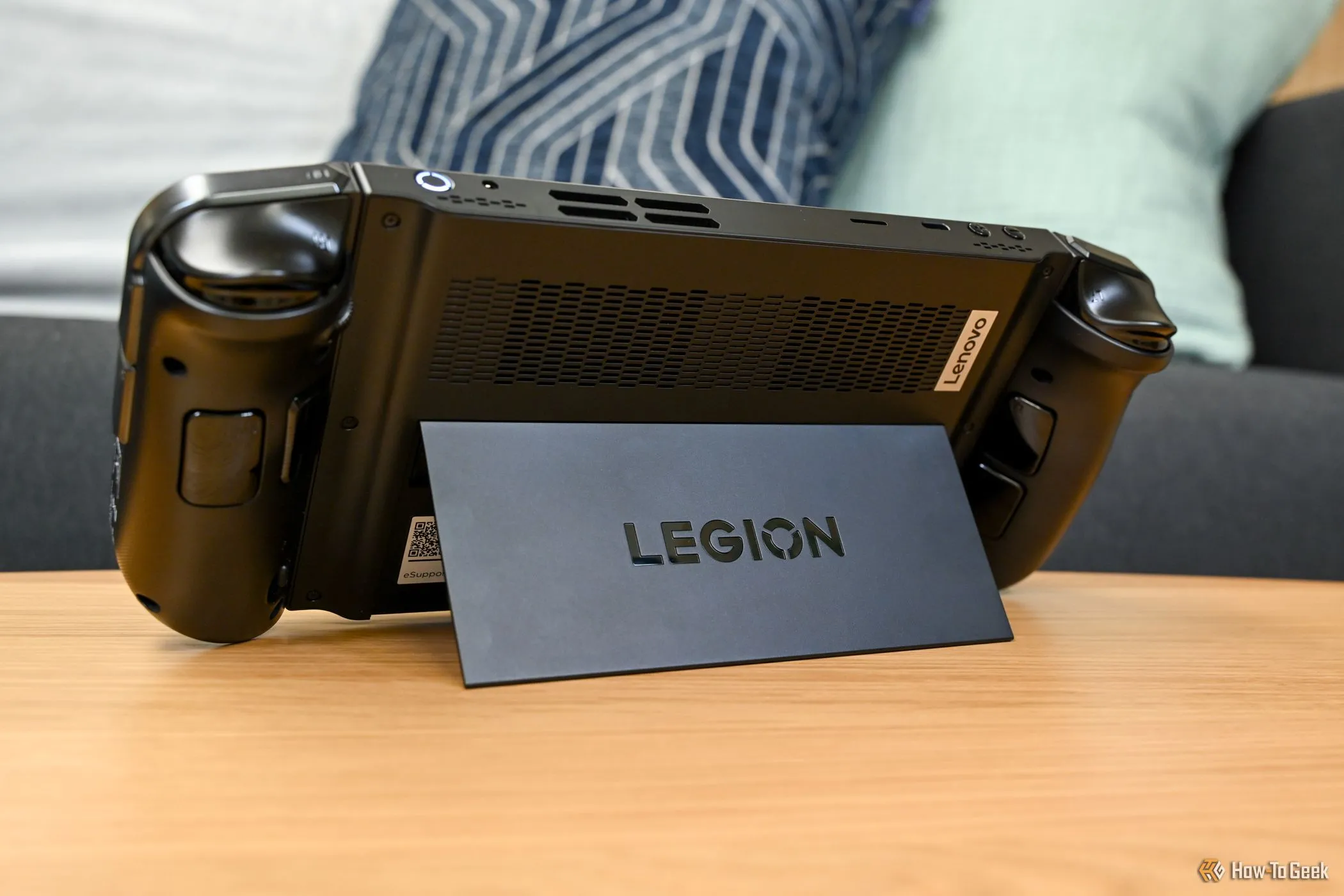 Hình ảnh Lenovo Legion Go đời đầu đang sử dụng chân đế, minh họa kích thước lớn và cổng kết nối.