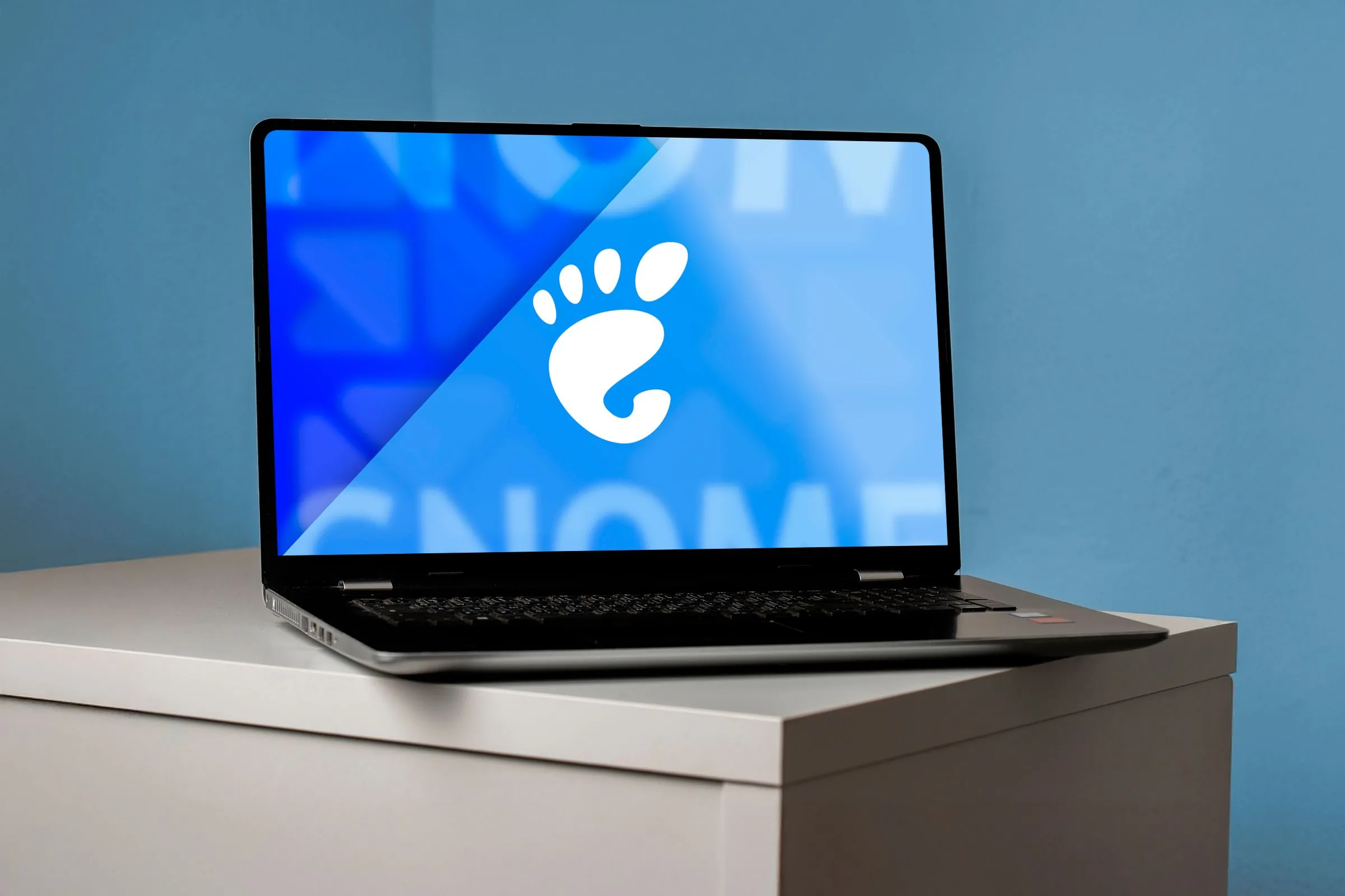 Hình ảnh một máy tính xách tay hiển thị logo GNOME trên màn hình, tượng trưng cho môi trường desktop.