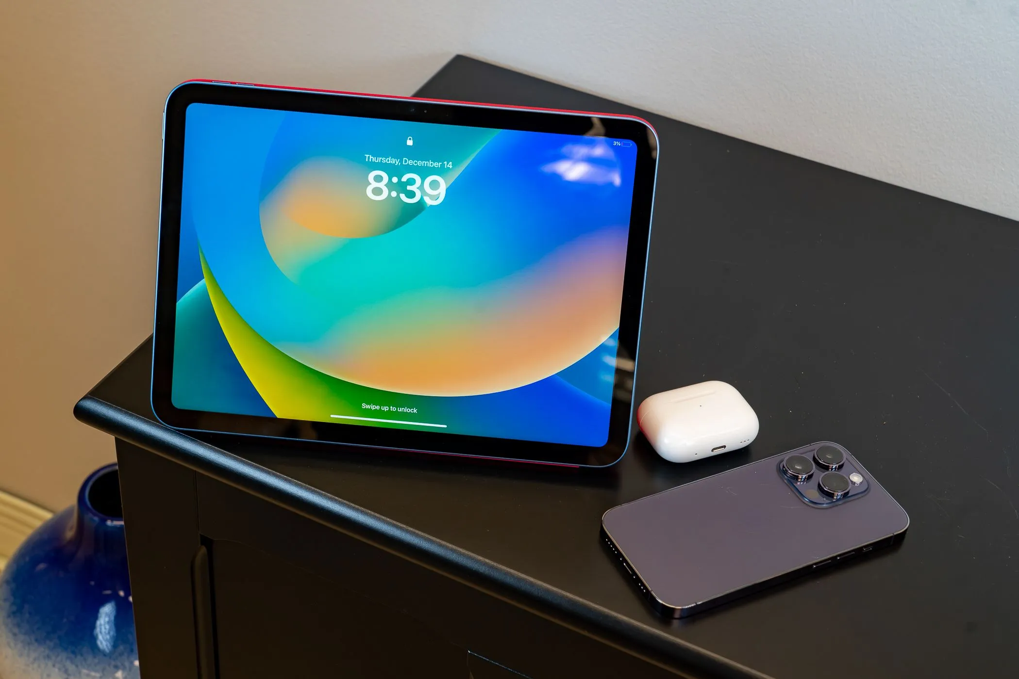iPad Air và iPhone 14 Pro Max cùng AirPods trên bàn làm việc, thể hiện hệ sinh thái Apple và tiềm năng kết nối 5G cho MacBook.