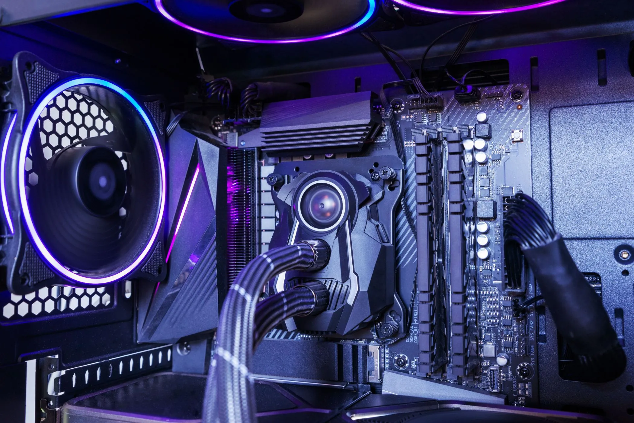 Khối tản nhiệt nước AIO của CPU được bao quanh bởi quạt RGB bên trong máy tính, minh họa hệ thống tản nhiệt và hướng luồng khí đa dạng.