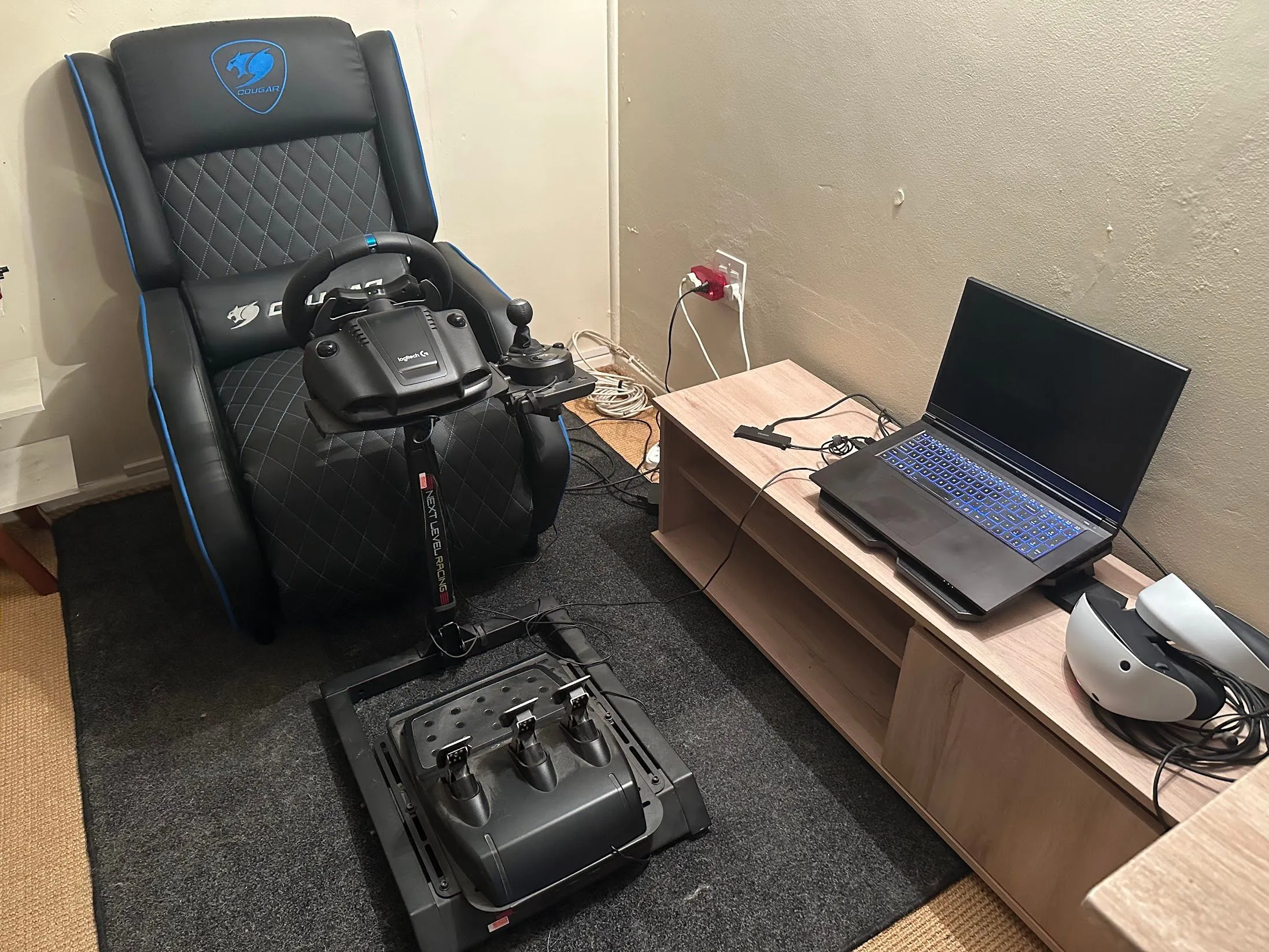 Laptop gaming đặt gần bộ thiết bị VR và mô phỏng đua xe