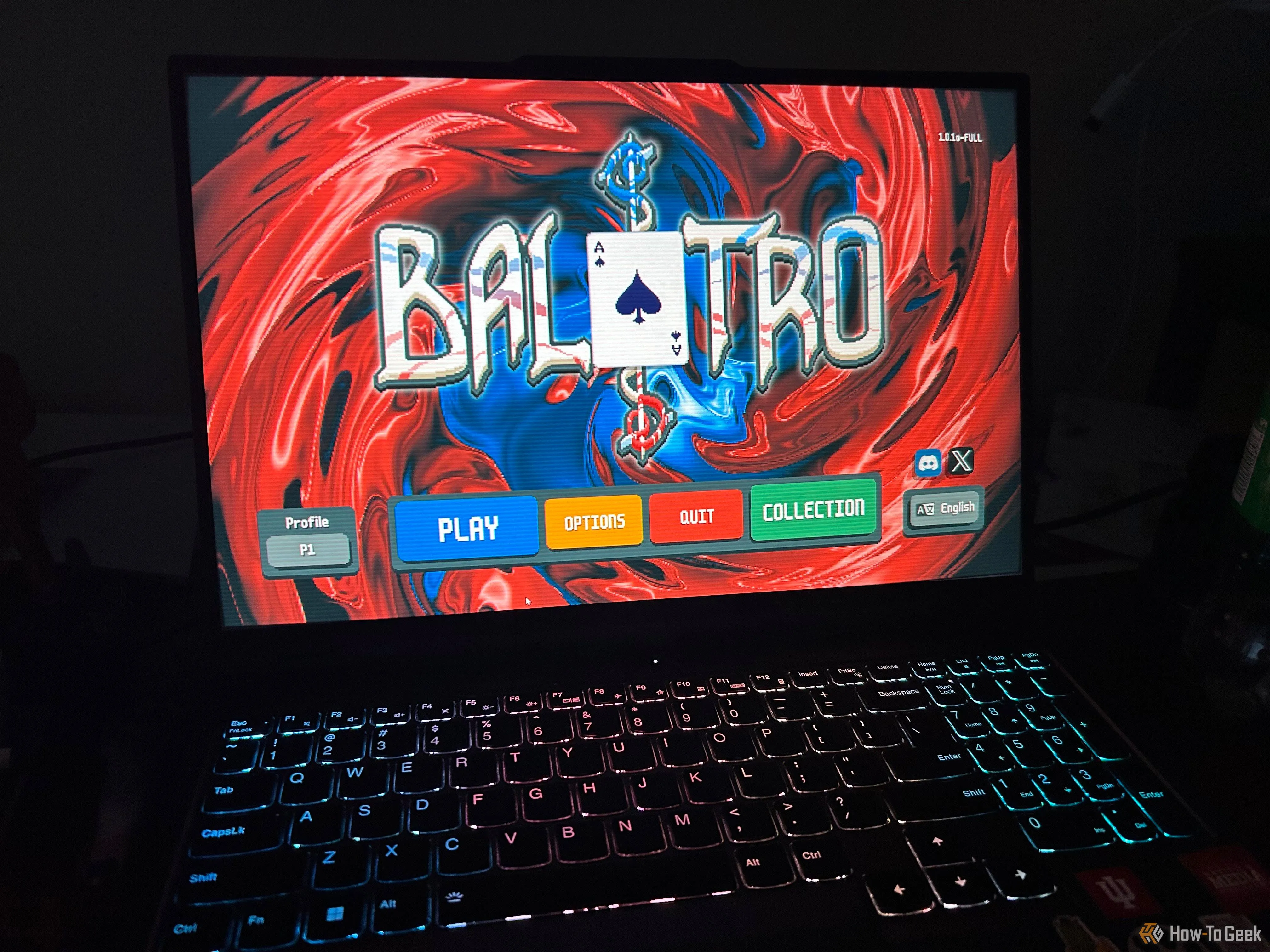 Màn hình laptop trong phòng tối hiển thị màn hình tiêu đề game Balatro