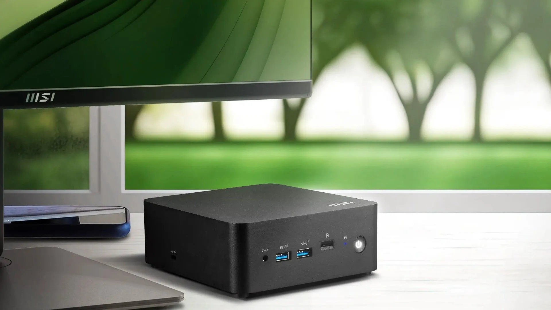 Mini PC MSI Cubi NUC AI Series đặt cạnh màn hình