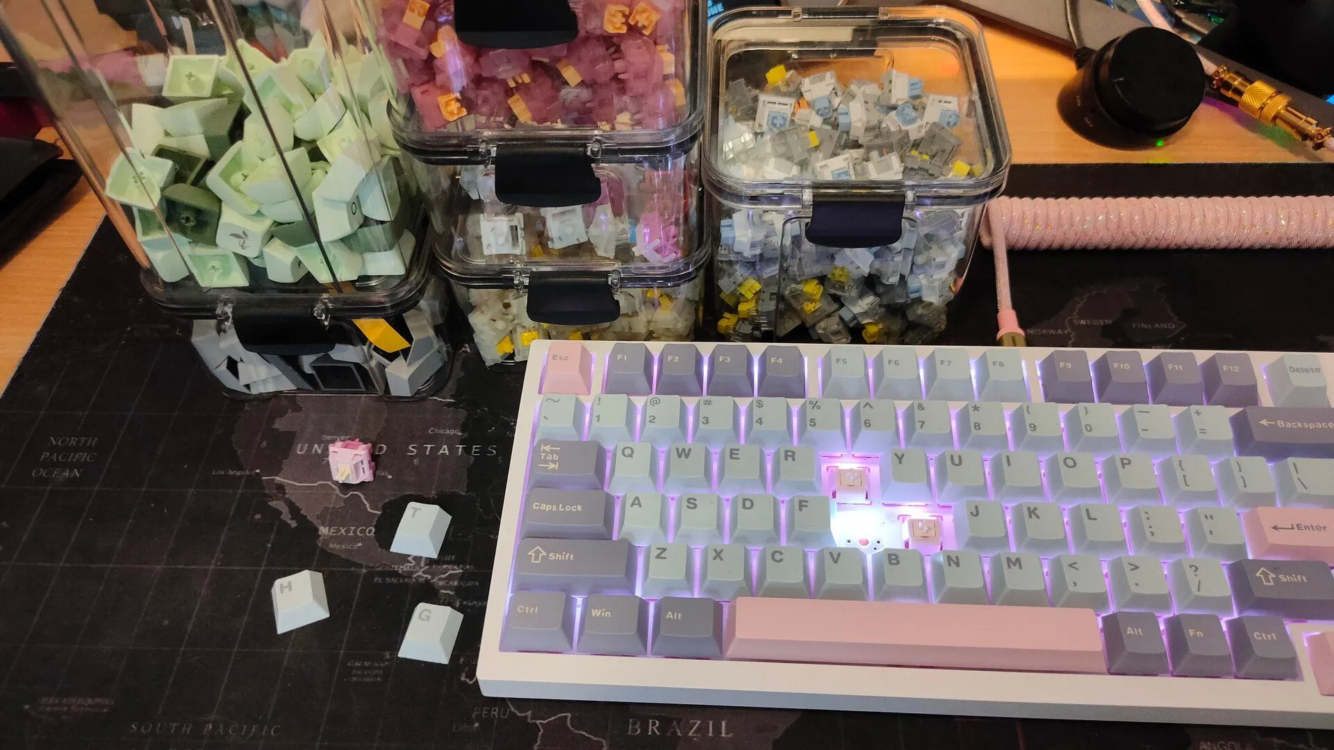 Một bàn phím cơ tùy chỉnh với keycaps màu sắc và các hộp đựng switch trong suốt ở phía sau, minh họa khả năng thay thế linh hoạt.