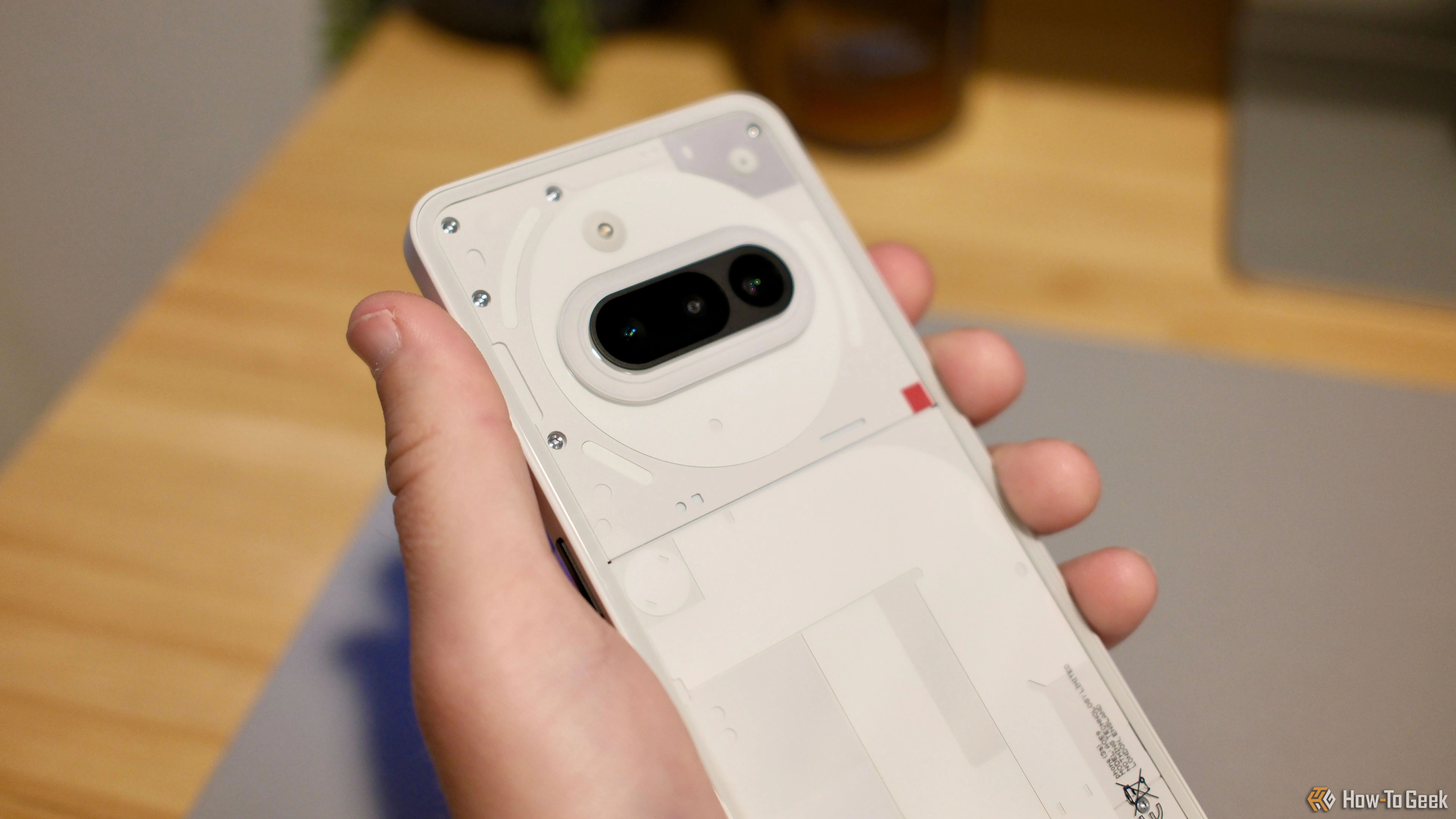 Một bàn tay cầm Nothing Phone (3a) thể hiện kích thước và thiết kế tổng thể của điện thoại