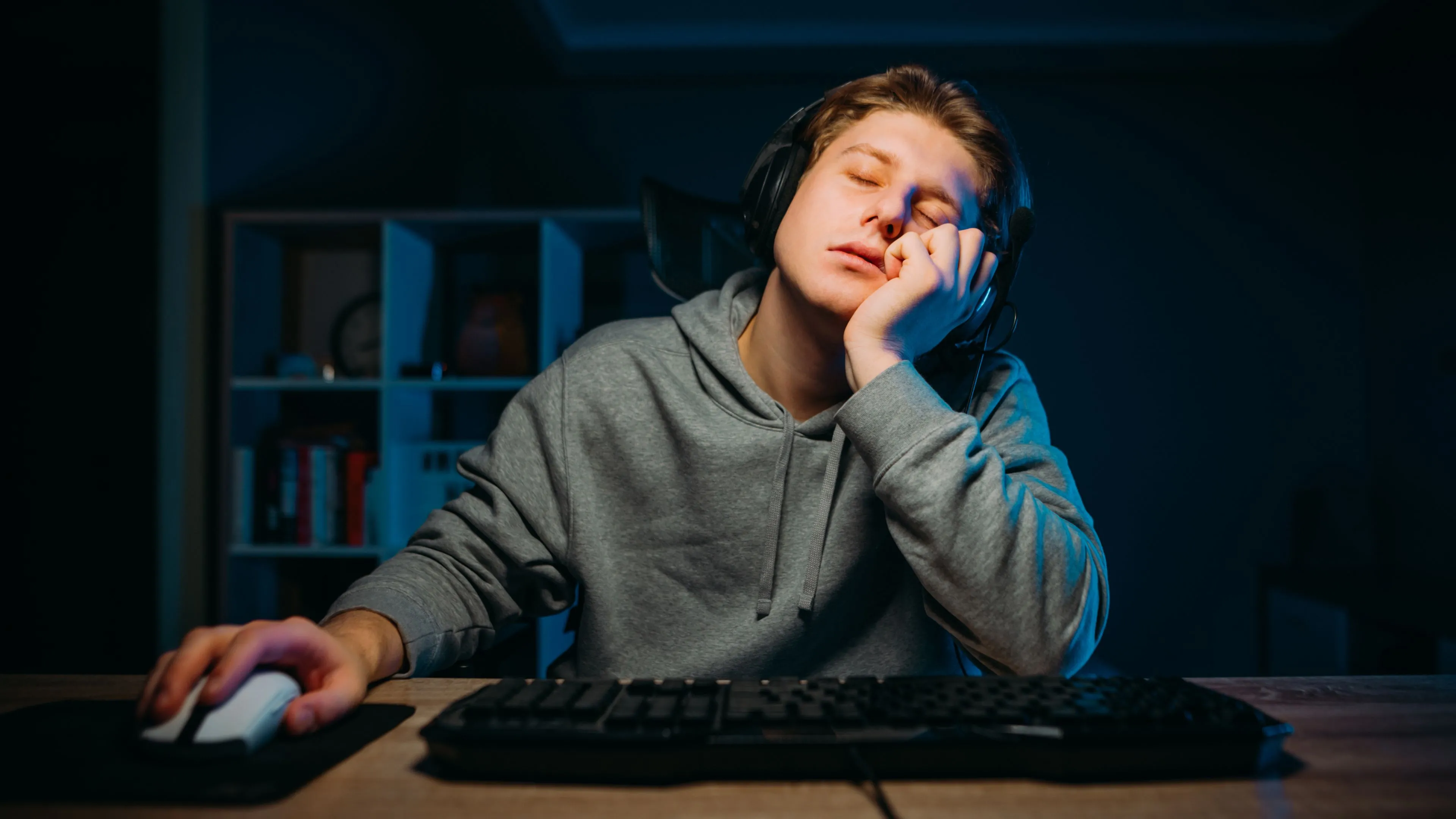 Một game thủ đang buồn ngủ, thể hiện sự thiếu hứng thú với thị trường game kém cạnh tranh.