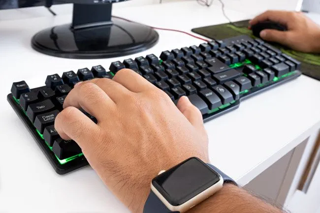 Một game thủ đang chơi game trên PC, sử dụng bàn phím WASD và chuột, thể hiện việc sử dụng chuột gaming trong trải nghiệm thực tế.