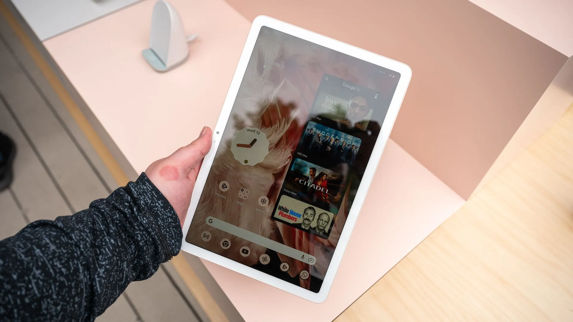Một người đang cầm máy tính bảng Google Pixel Tablet ở chế độ dọc, thể hiện tính linh hoạt khi sử dụng.