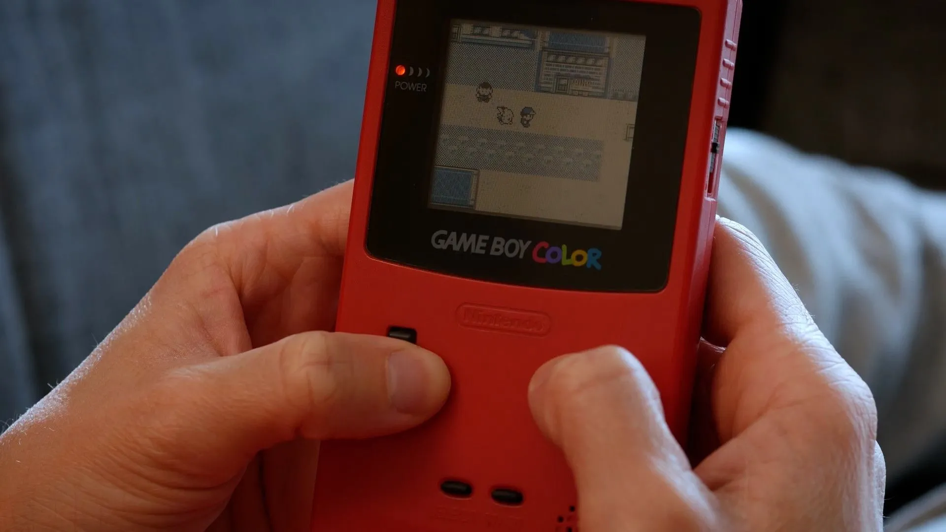 Người chơi game Pokemon Yellow trên Game Boy Color để giải trí khi di chuyển
